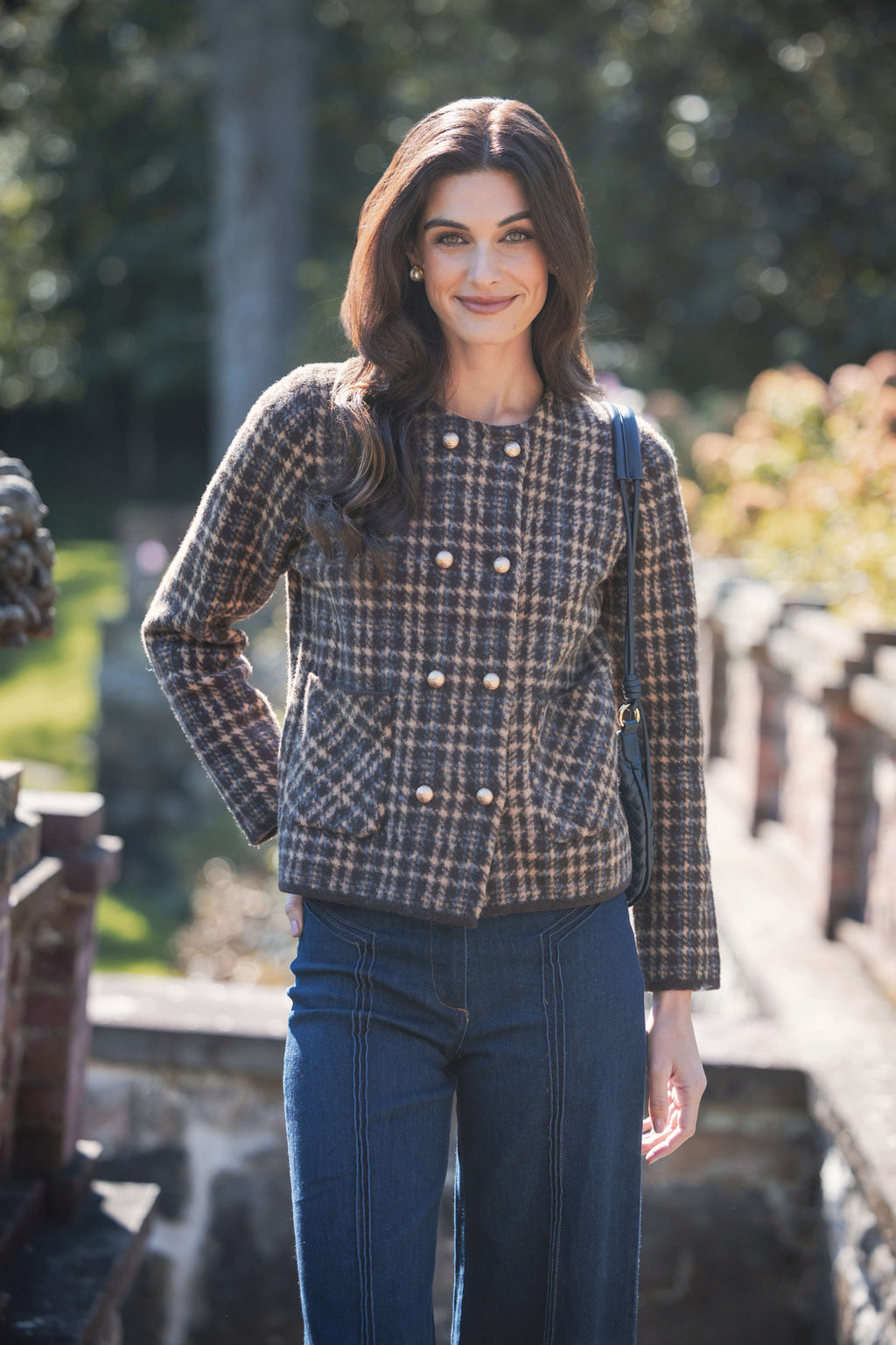 Brown and cream houndstooth tweed jacket with double-breasted pearl buttons and long sleeves.