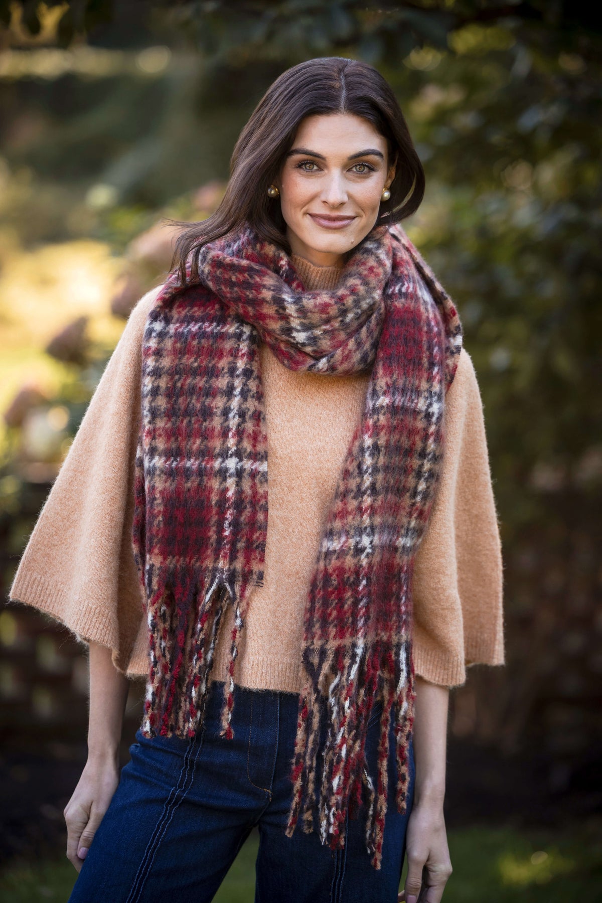 Beige turtleneck sweater with burgundy plaid scarf, worn with dark jeans.