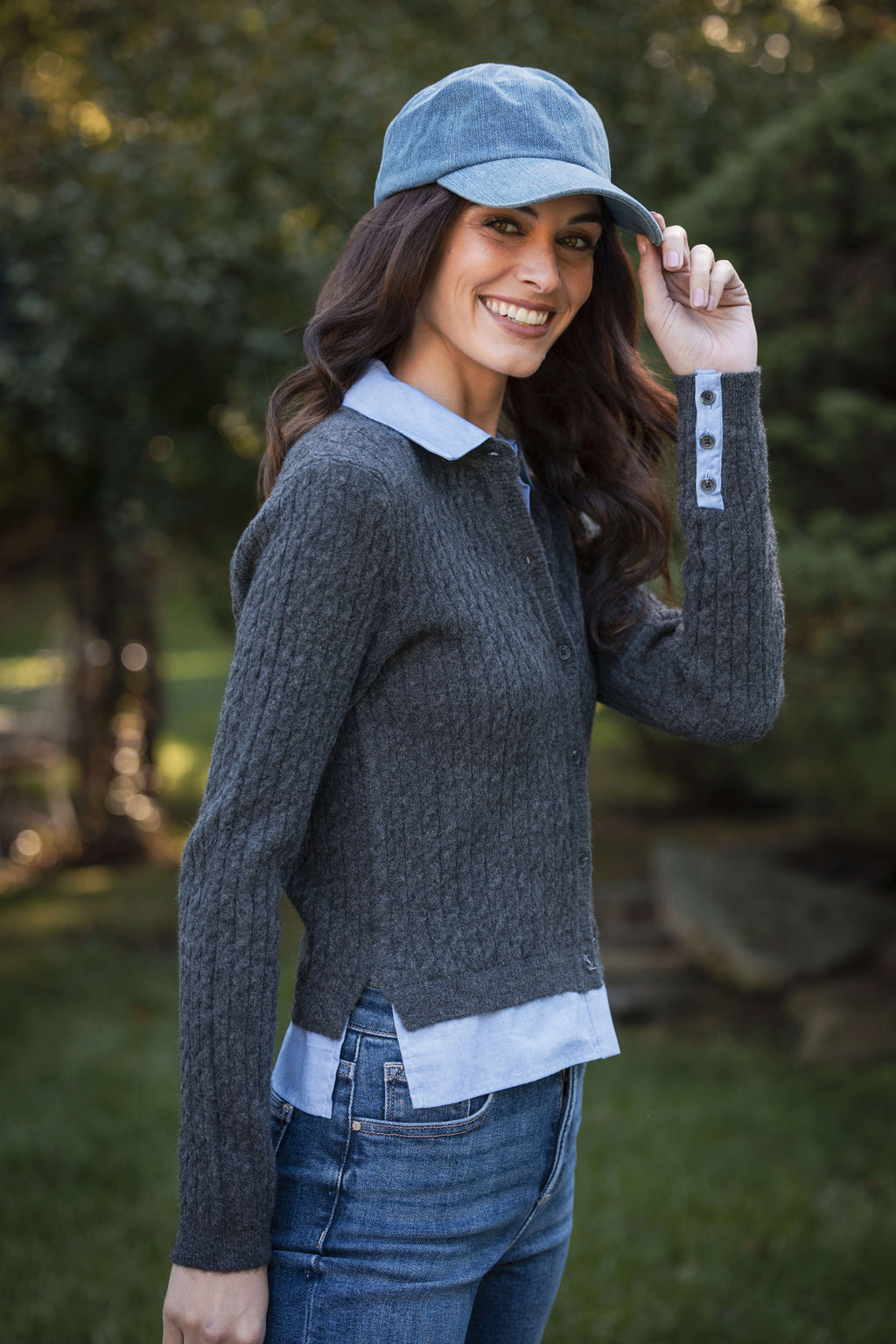 Charcoal knit top with light blue collar and cuff details, worn with dark jeans.