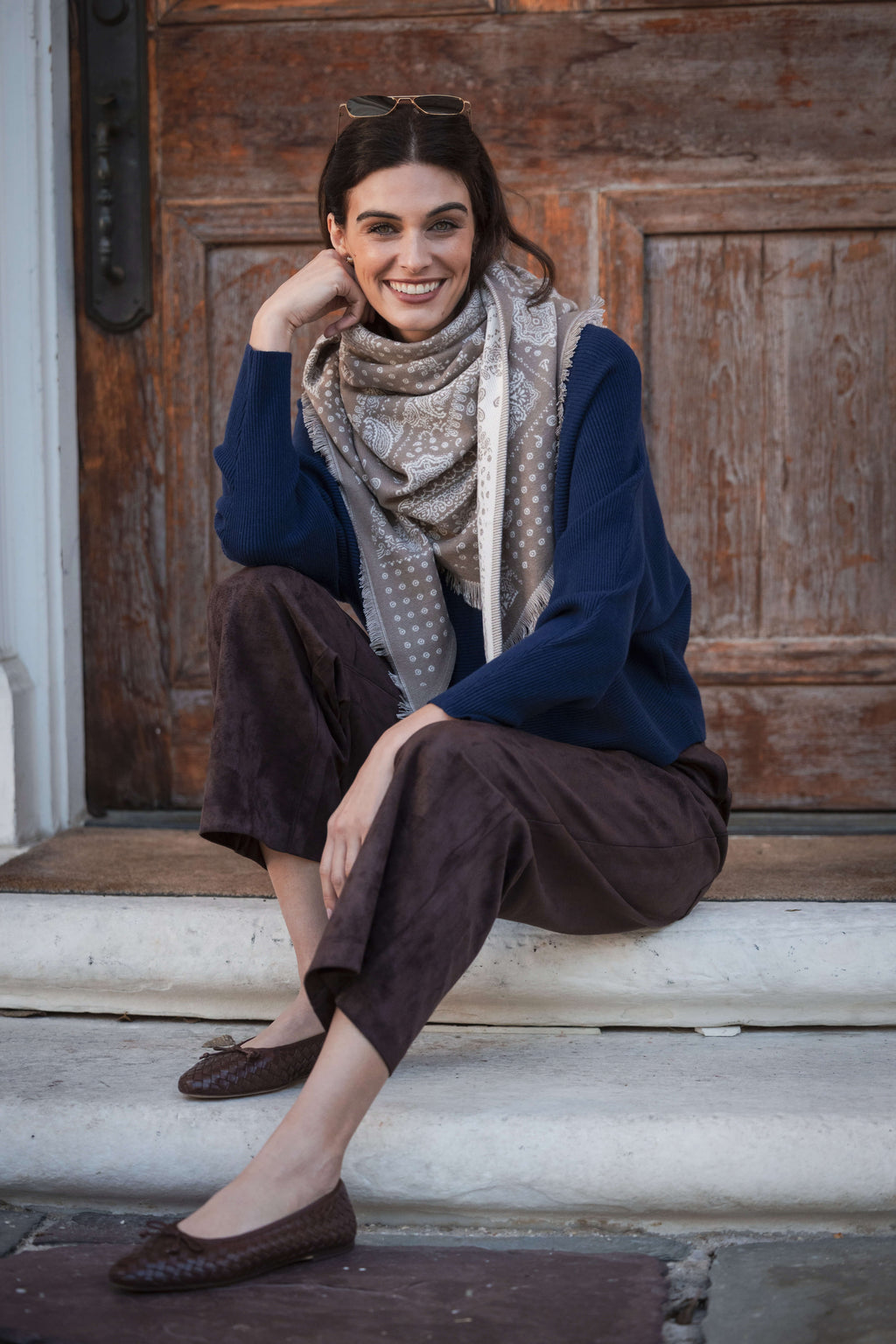Navy crewneck sweater with ribbed dolman sleeves, styled with brown pants and patterned scarf.