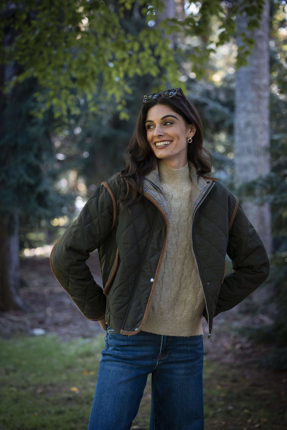 Beige lurex turtleneck sweater with ribbed knit texture worn under a black quilted jacket.