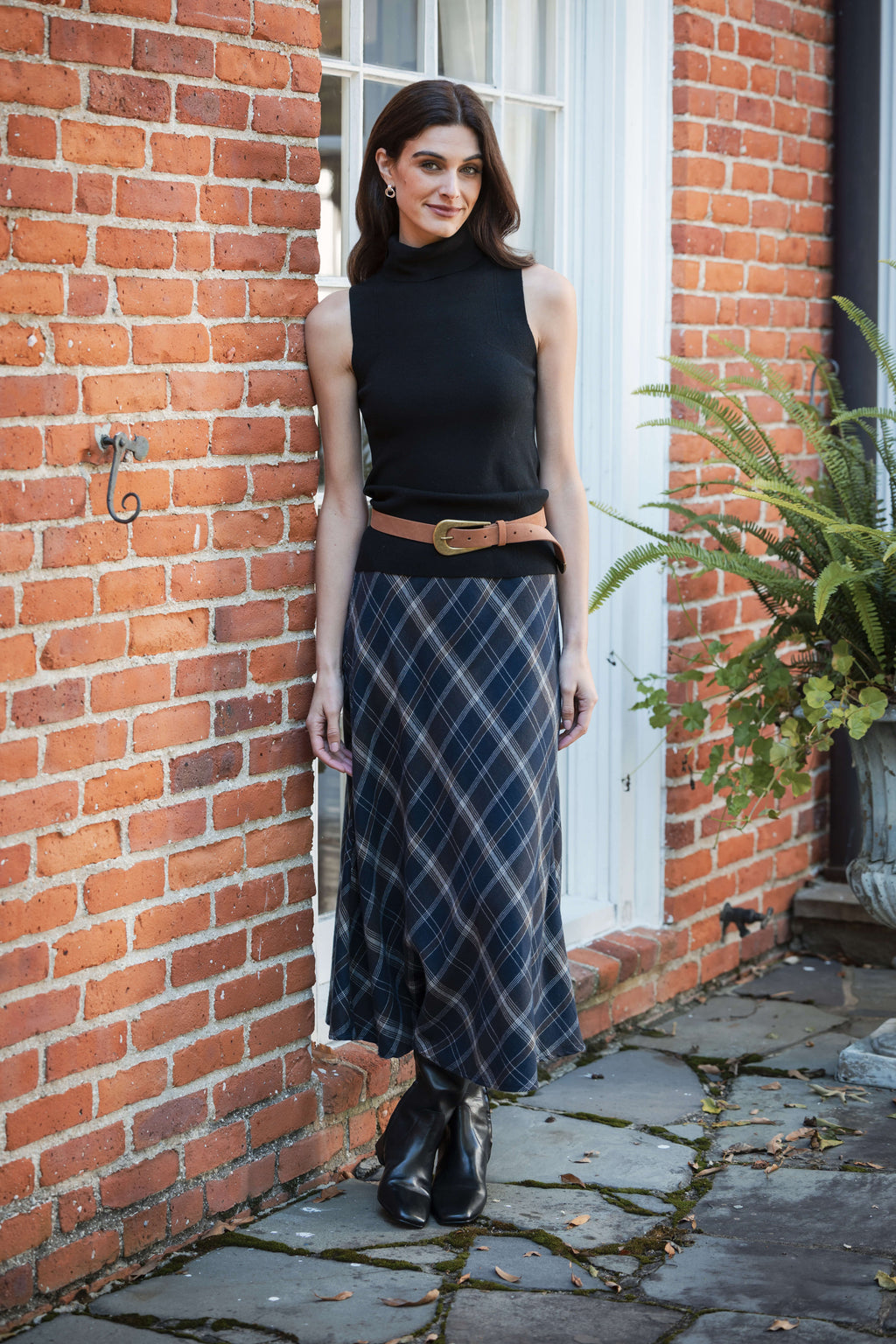 Navy and white diagonal plaid midi skirt worn with black sleeveless top and tan belt.