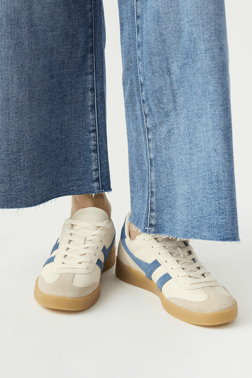 White leather low-top sneakers with blue side stripes and gum rubber sole