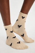 Beige ankle socks with black bow-heart pattern and ribbed cuffs
