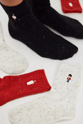 Speckled ribbed socks in black, red, and cream, each embroidered with a small toy soldier, shown worn and laid flat.