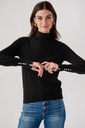 Black knit turtleneck top with ribbed collar and studded button cuffs.