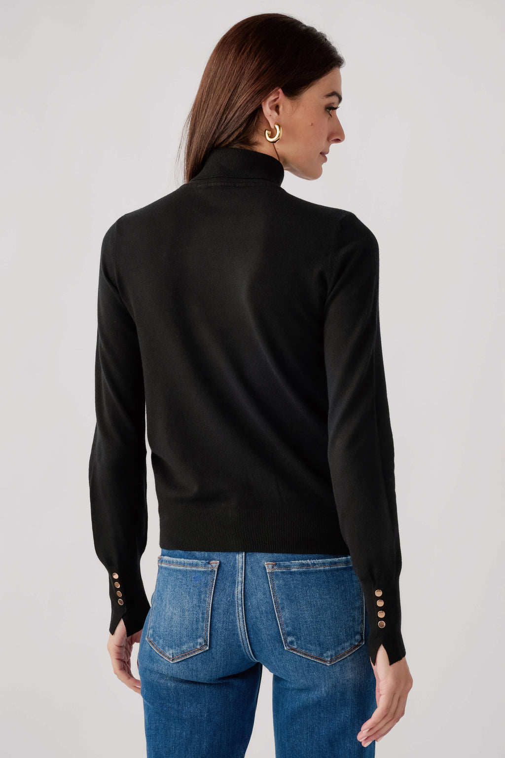 Black knit turtleneck top, long sleeves, ribbed back yoke; studded cuffs.