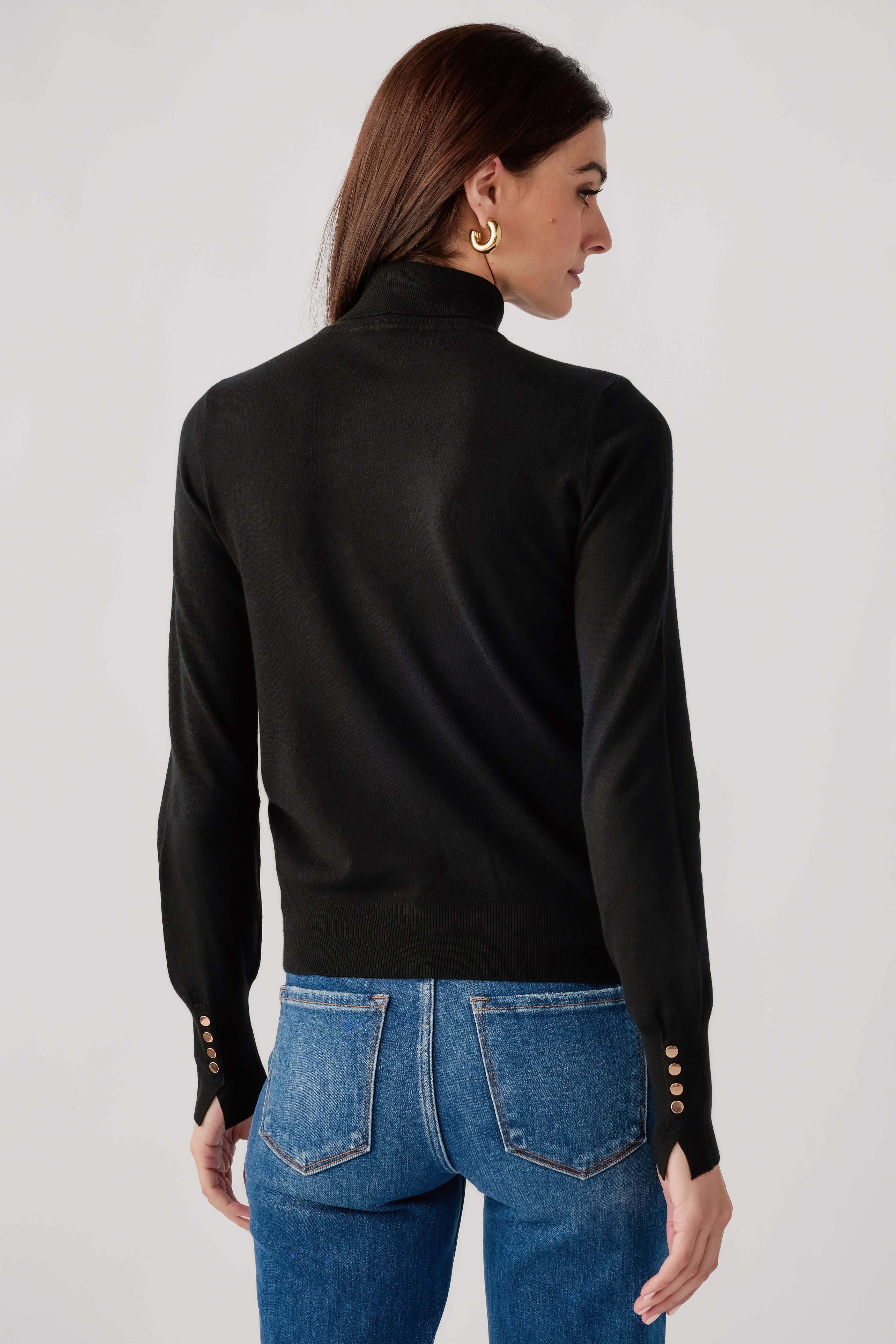 Black knit turtleneck top, long sleeves, ribbed back yoke; studded cuffs.
