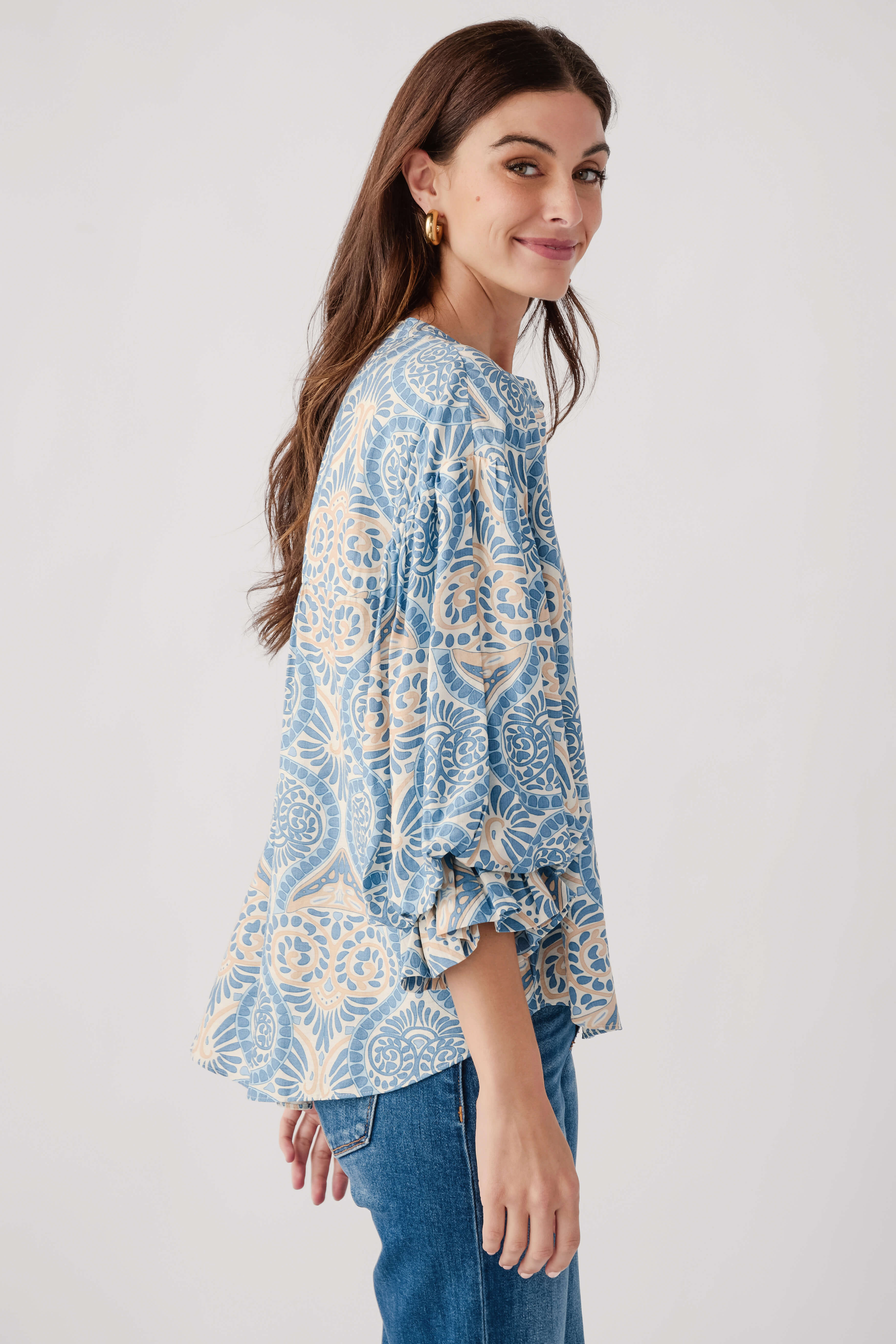 Blue damask print balloon-sleeve button-up top with round neckline, side view