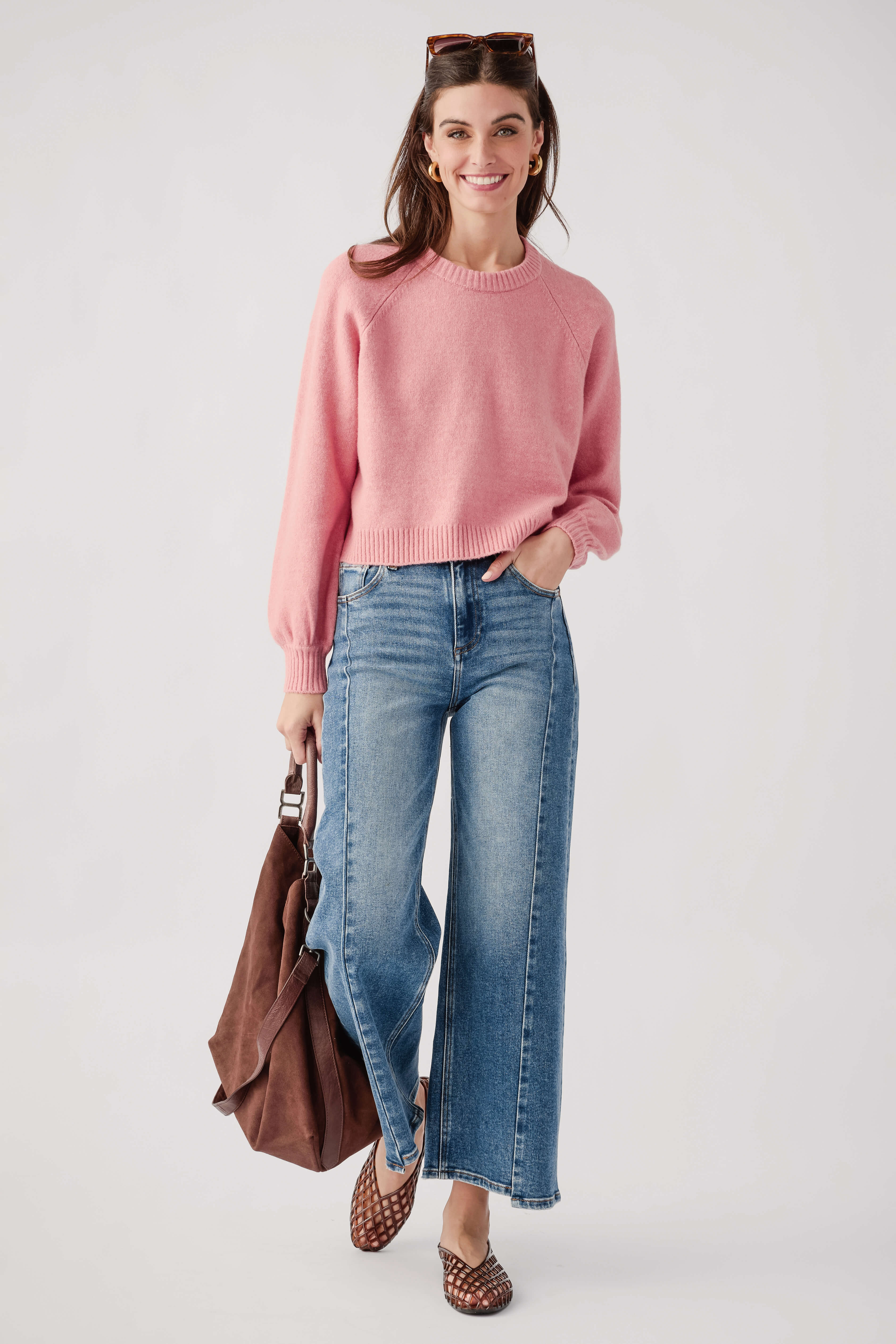 Pink crewneck knit sweater with long sleeves and ribbed cuffs, front view