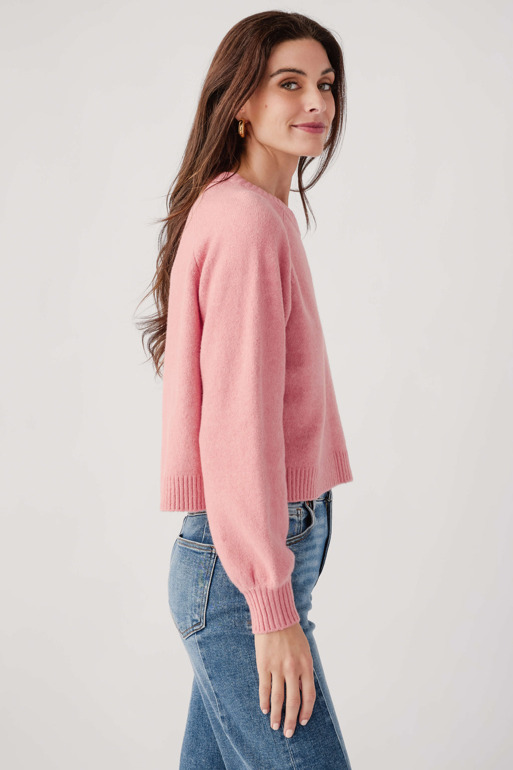 Pink crewneck knit sweater, side view with ribbed hem and cuffs