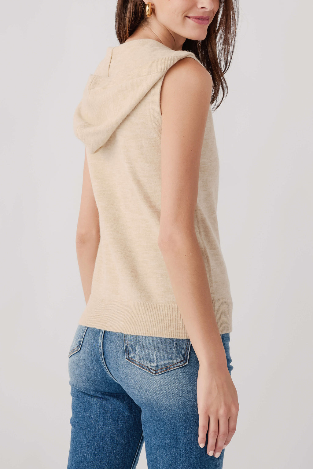 Oatmeal sleeveless zip vest with hood draped at back, front zipper