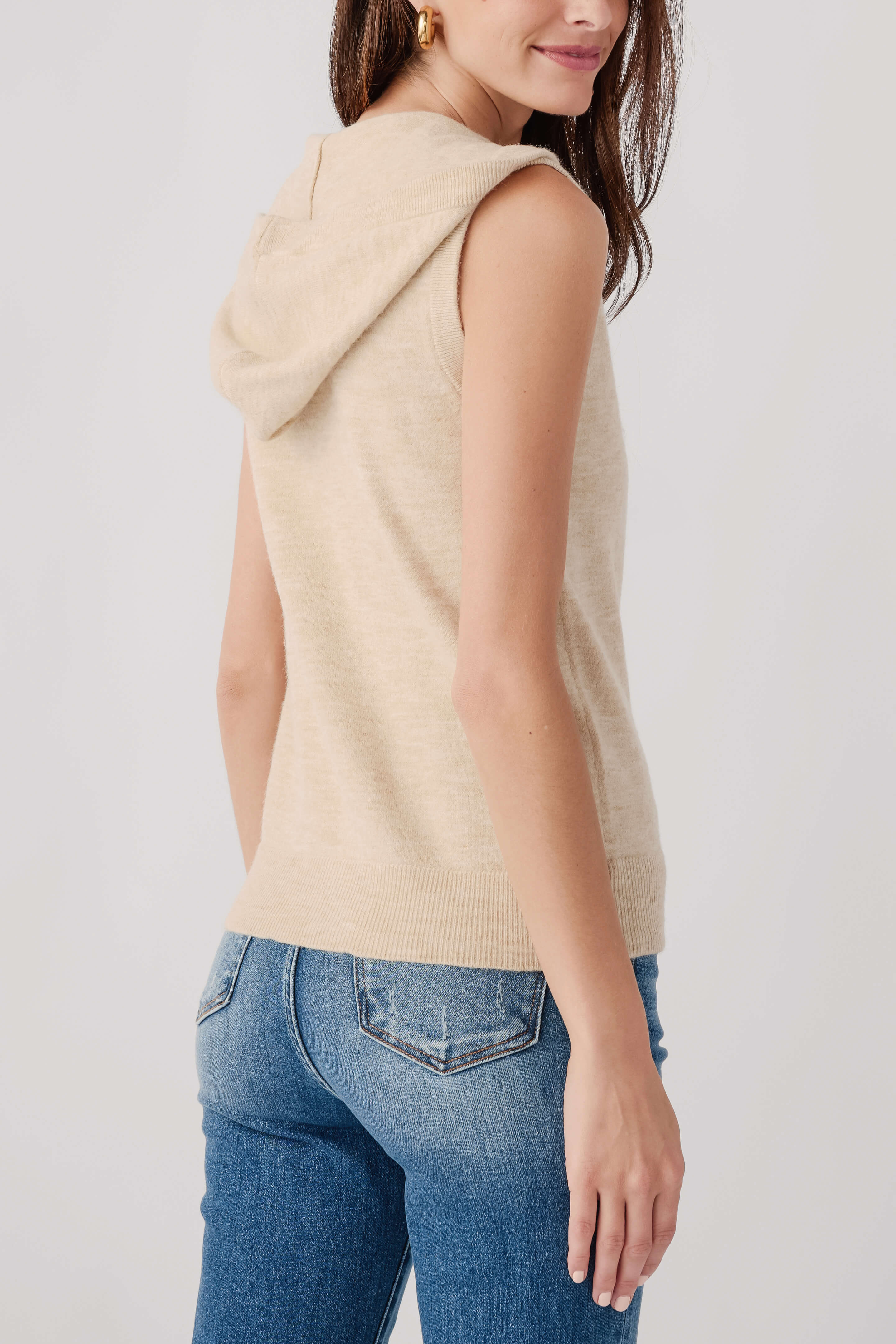 Oatmeal sleeveless zip vest with hood draped at back, front zipper