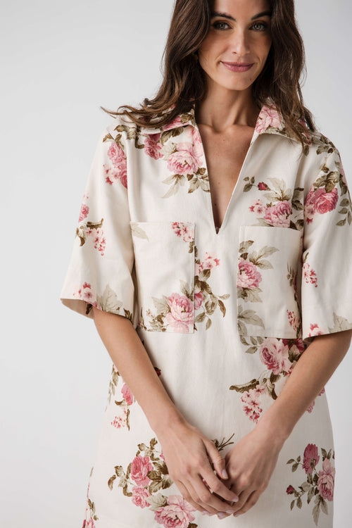 Natural pink floral dress close-up with V-neck and short sleeves, button-front detail