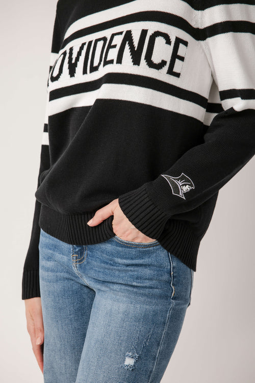 Black sweater cuff with knit stripes and small Providence emblem on the sleeve