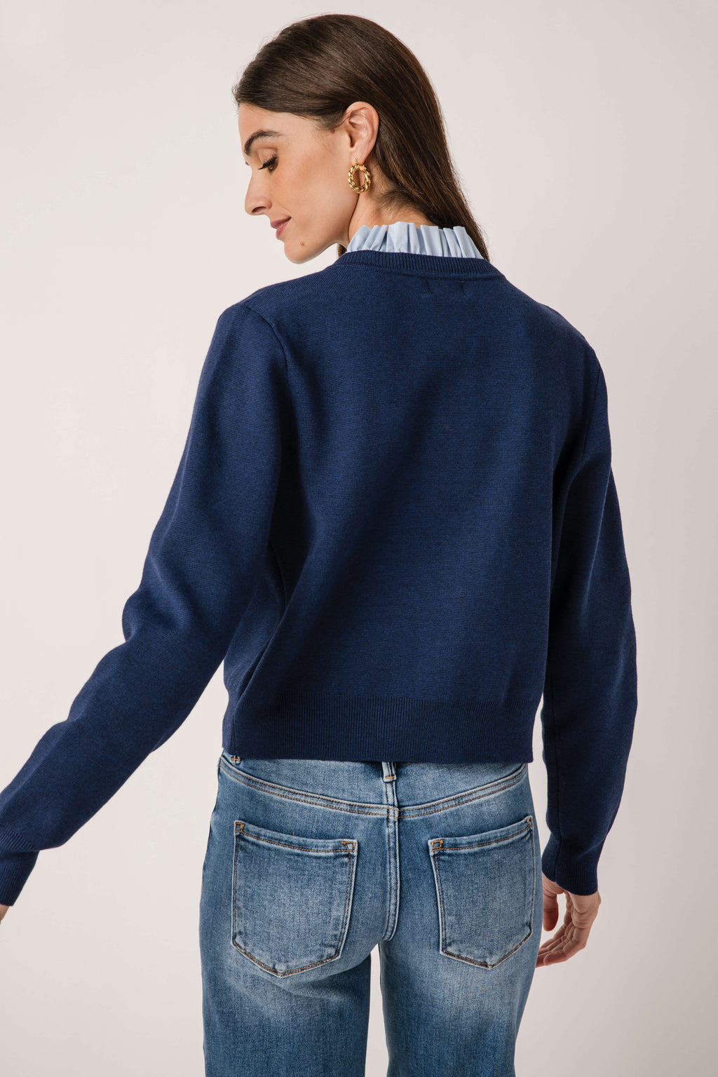 Navy ruffle-collar cardigan, long sleeves, ribbed trim, back view