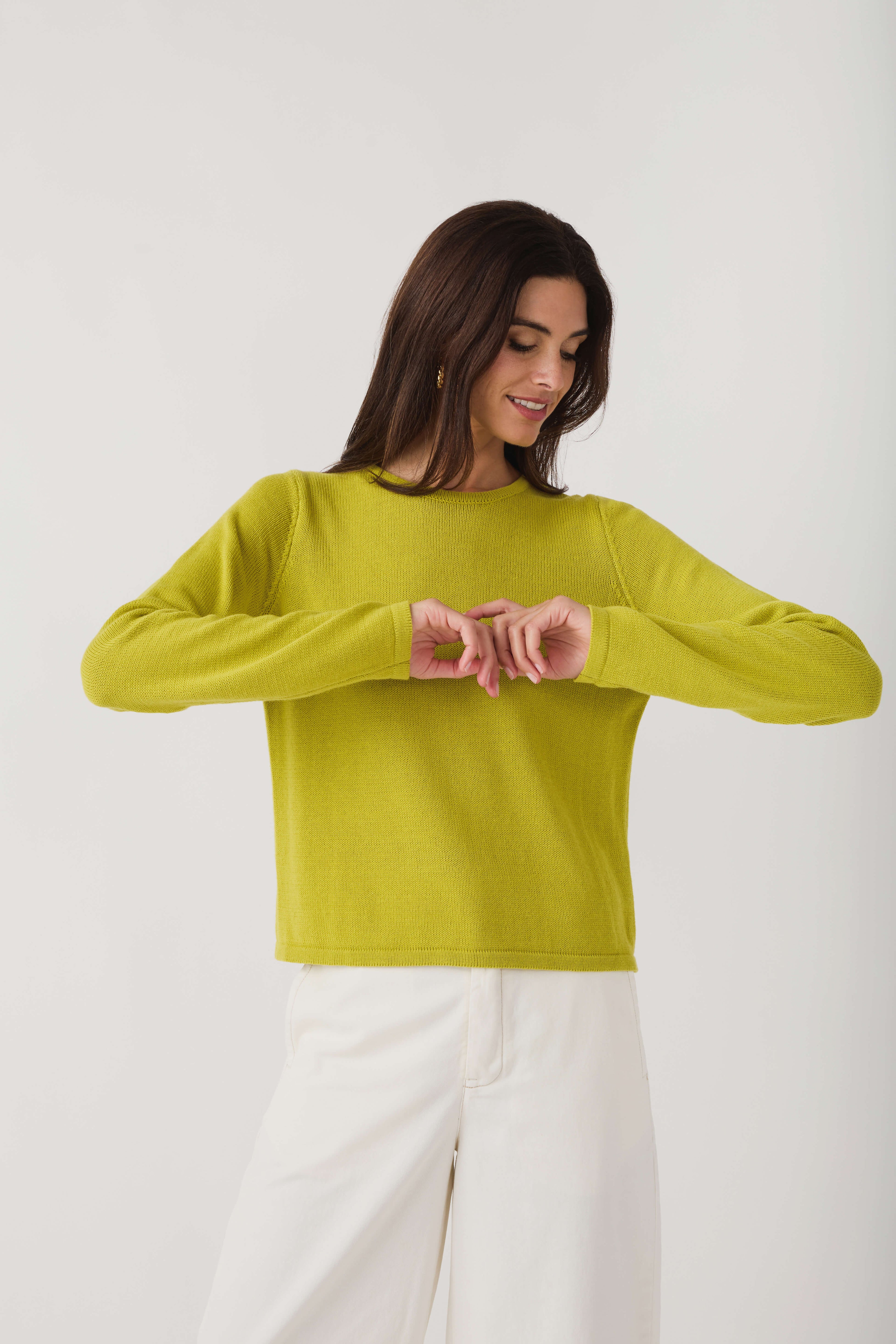 Lime knit crewneck sweater with long sleeves, hands at neckline detail