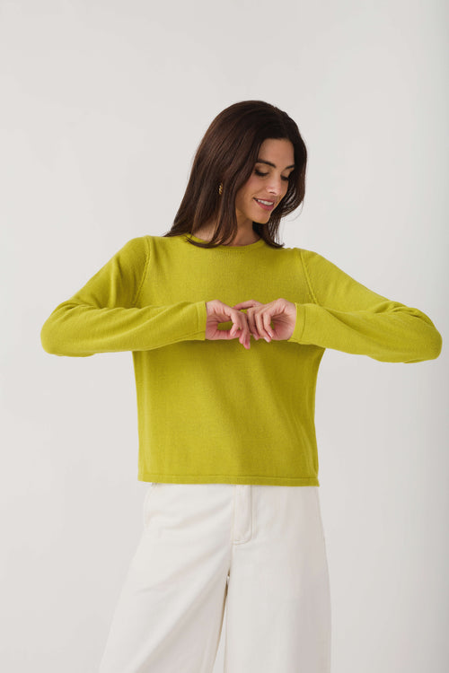 Lime knit crewneck sweater with long sleeves, hands at neckline detail