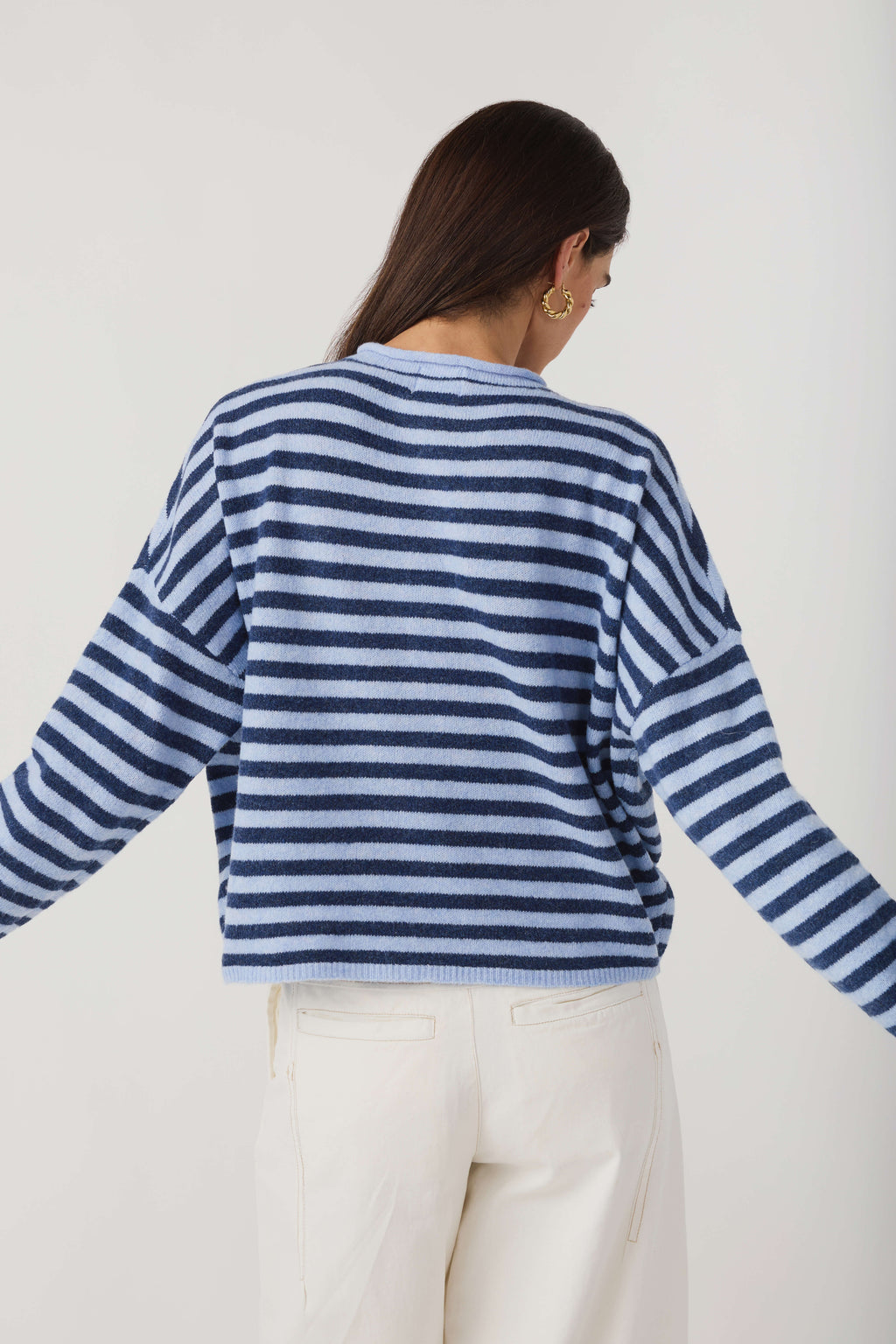 Back view of blue-and-white striped cardigan with long sleeves and button front