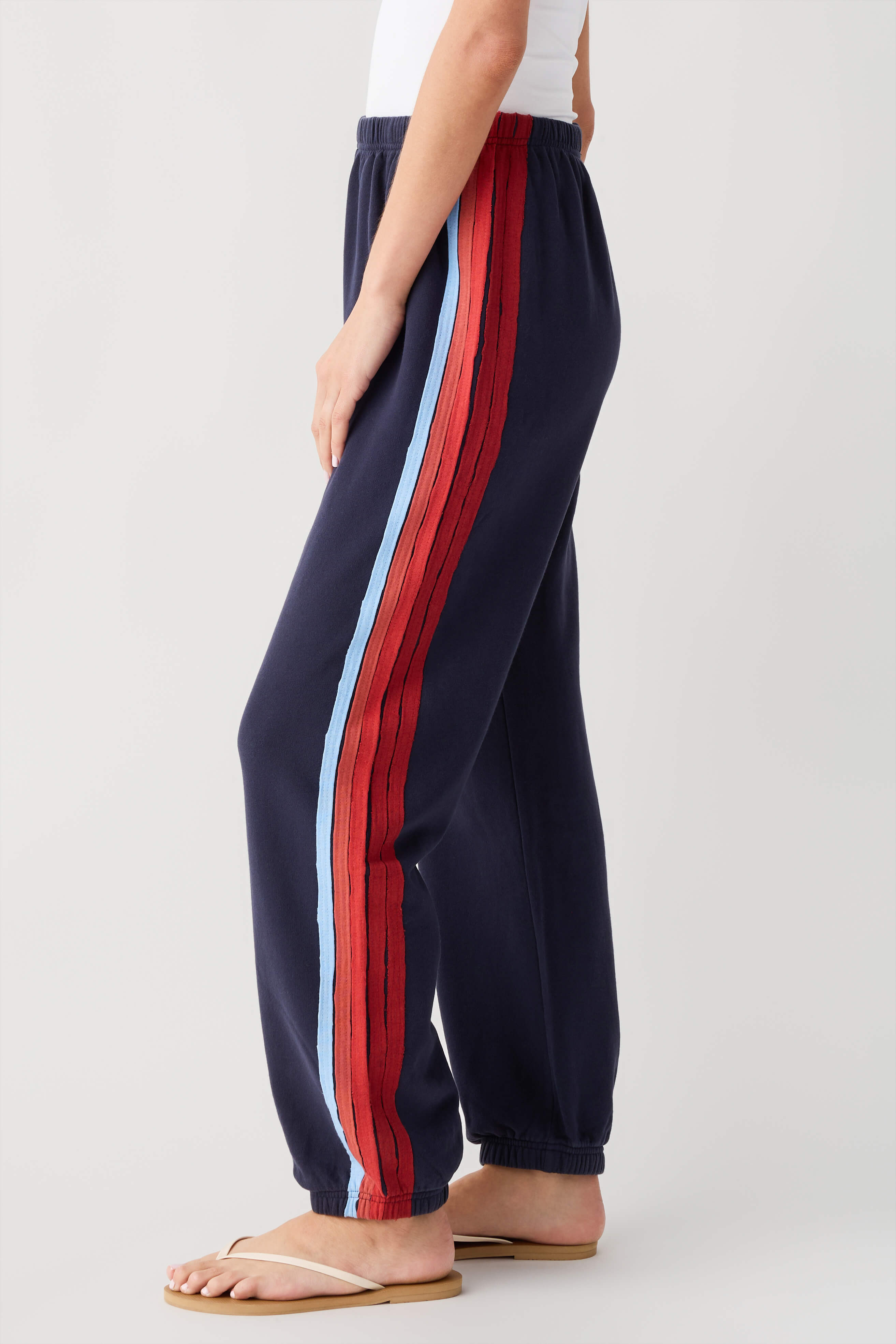 Navy jogger pants with vertical red stripe and white side panel