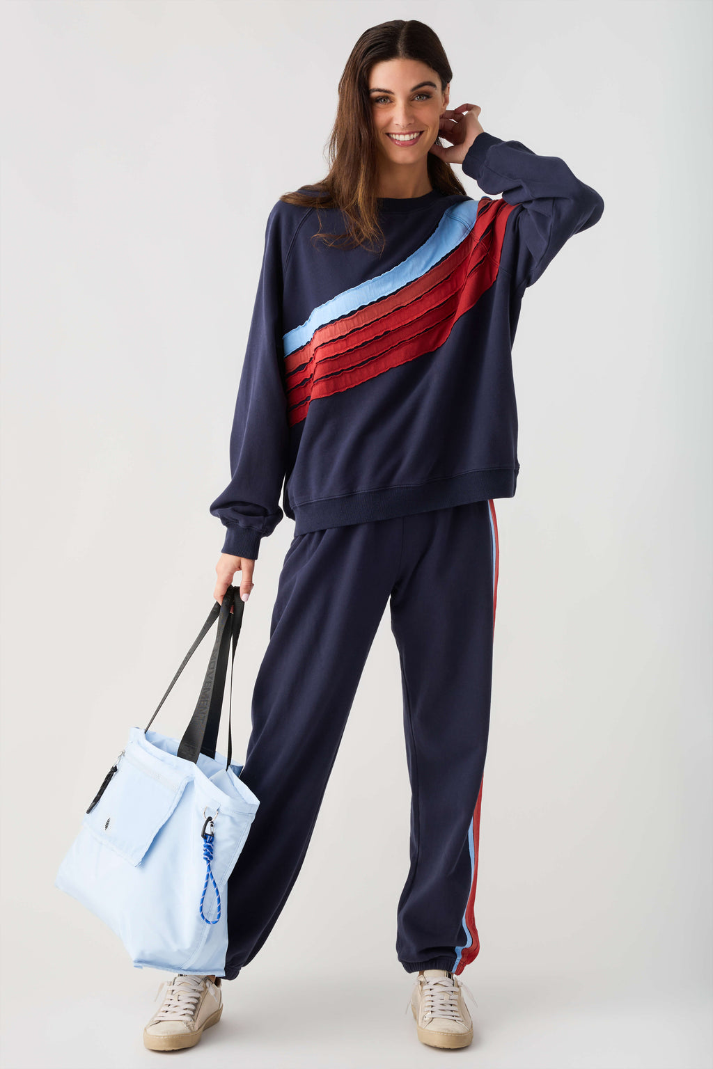 Navy sweatshirt with light blue and red diagonal stripe panel, relaxed crew neck