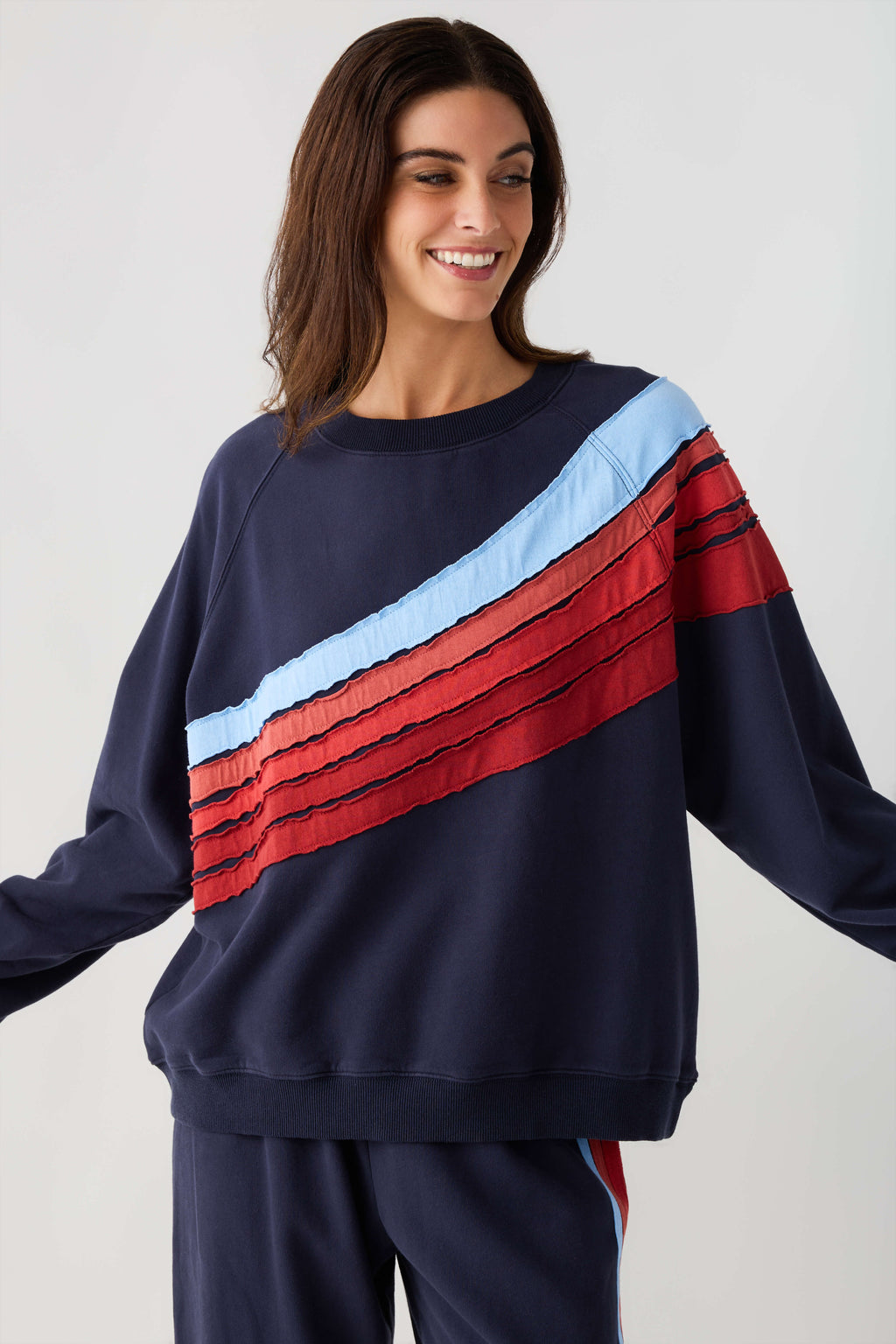 Navy crewneck sweatshirt with light blue and red stripe detail across chest