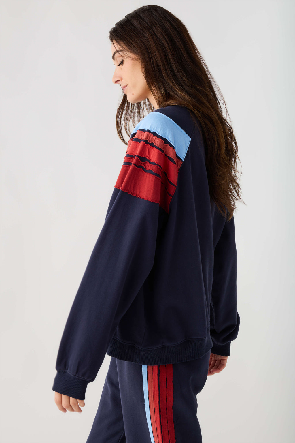 Navy sweatshirt with light blue and red stripe across sleeve and chest