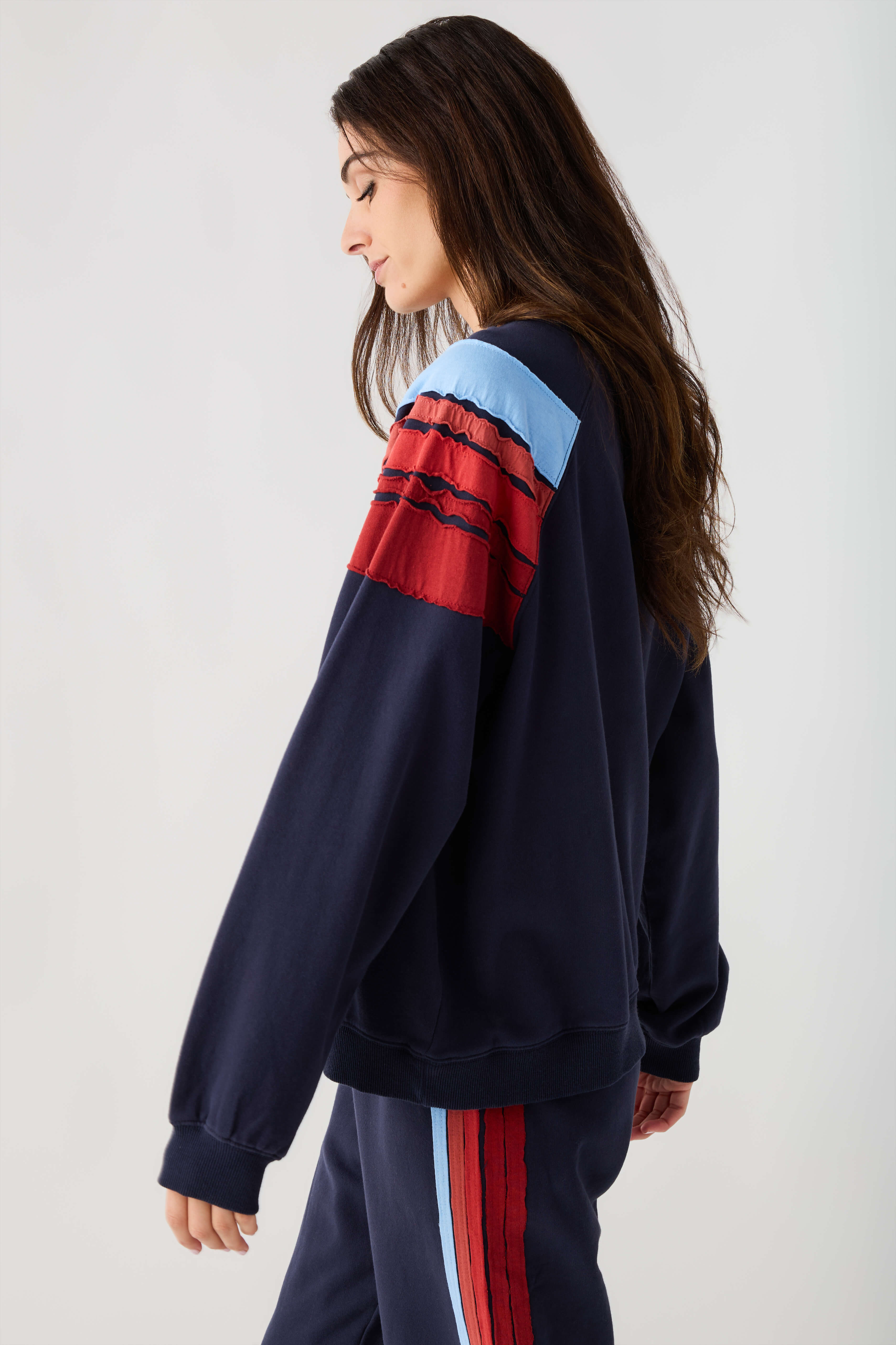 Navy sweatshirt with light blue and red stripe across sleeve and chest