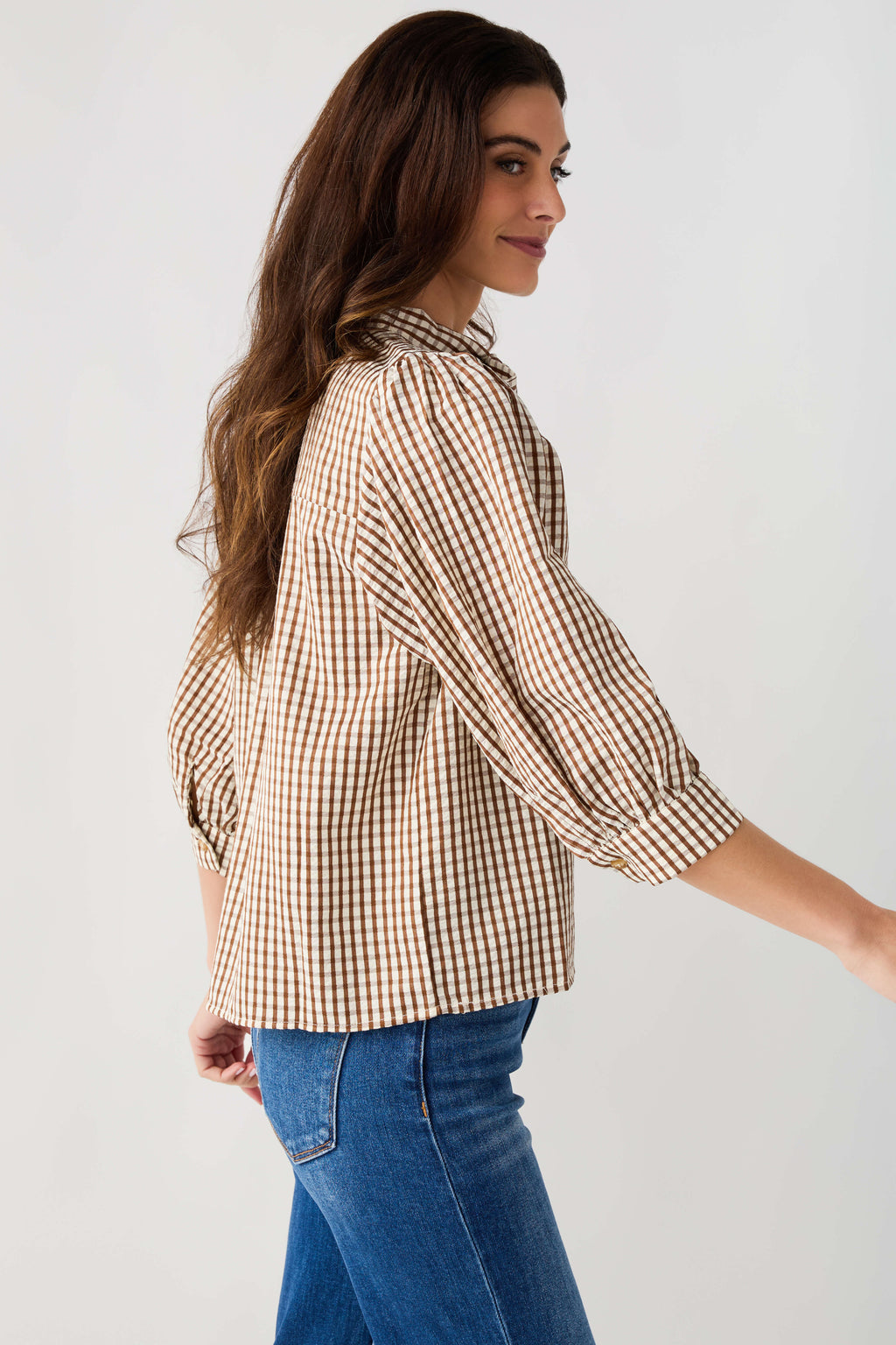 Brown gingham tie-neck blouse shown from the side with gathered puff sleeves