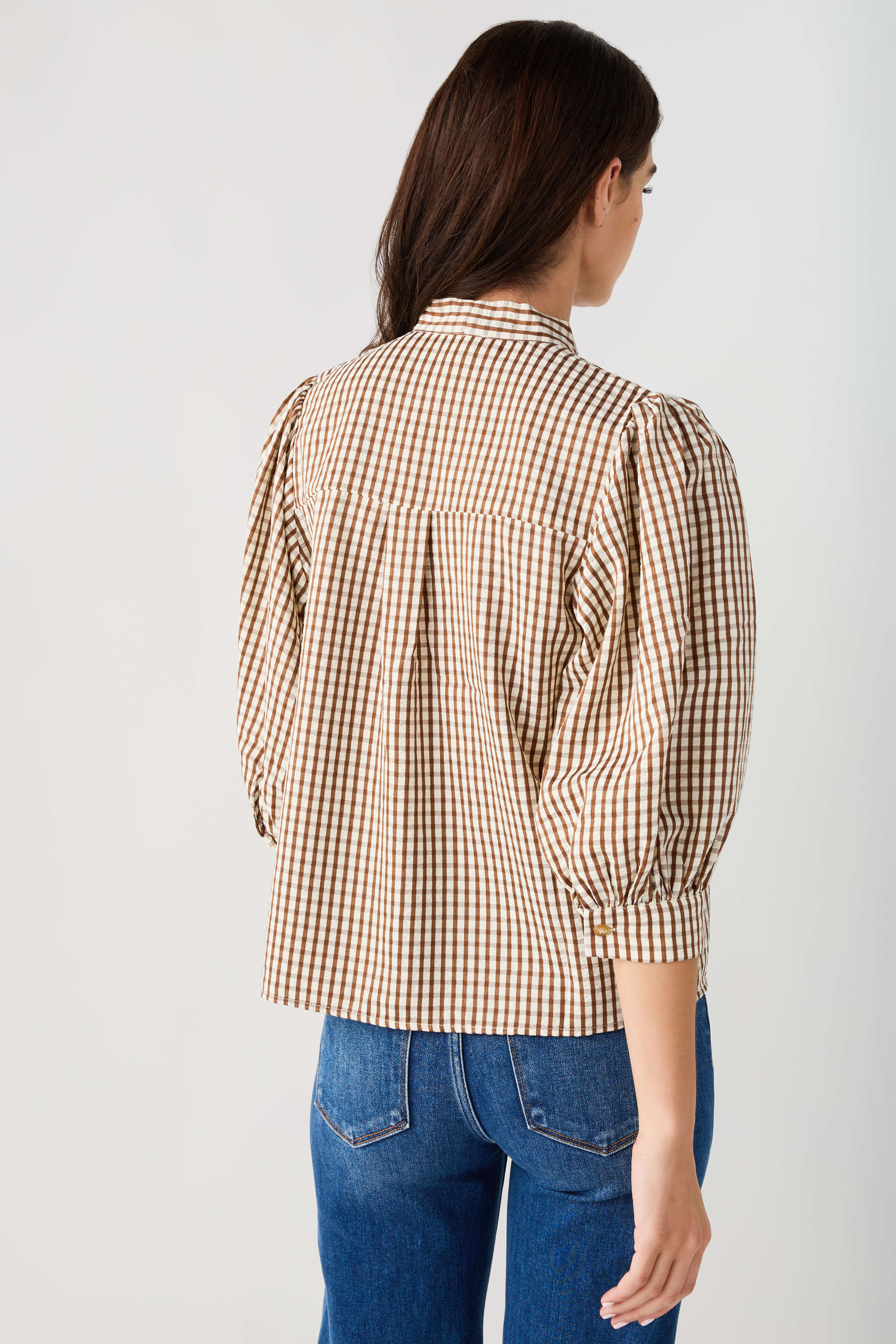 Brown gingham tie-neck blouse back view with gathered sleeves and button detailing
