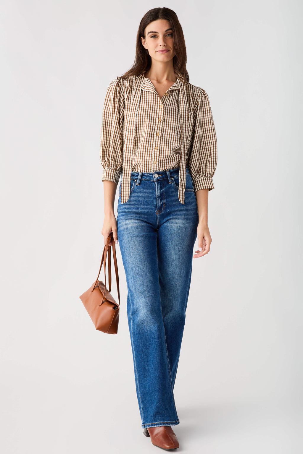Brown gingham tie-neck blouse with ruffled collar and quarter puff sleeves