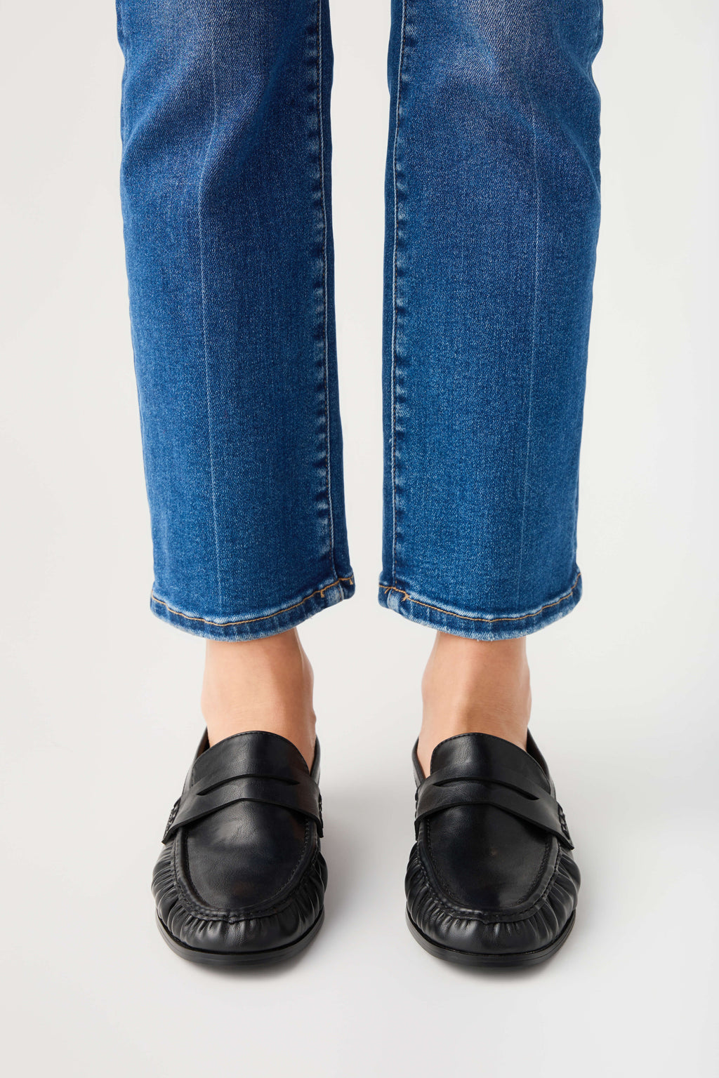 Black leather loafer pair shown from back with low heel and rounded toe