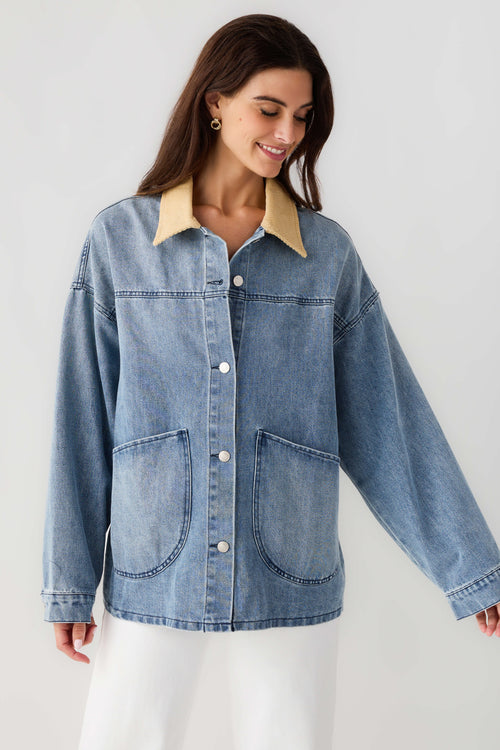 Light blue denim jacket with tan corduroy collar, chest pockets and button front