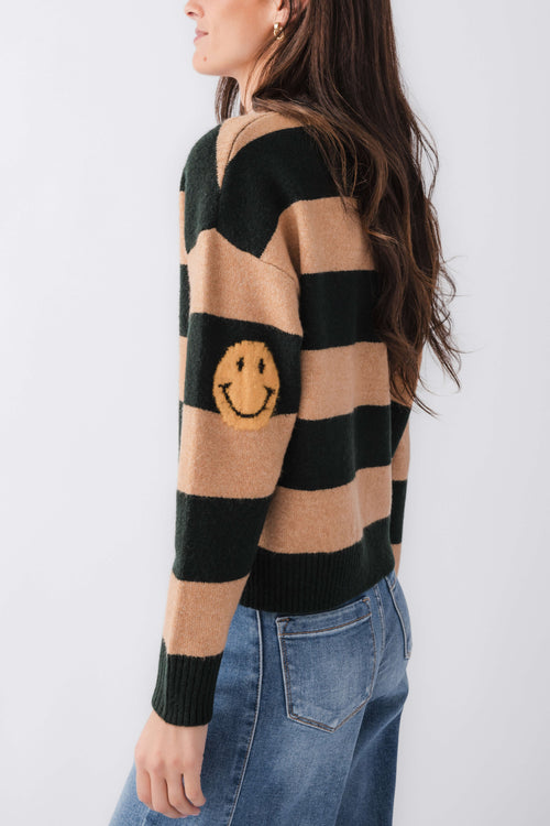 By Together striped sweater sleeve detail with smiley face patch, black and camel stripes.