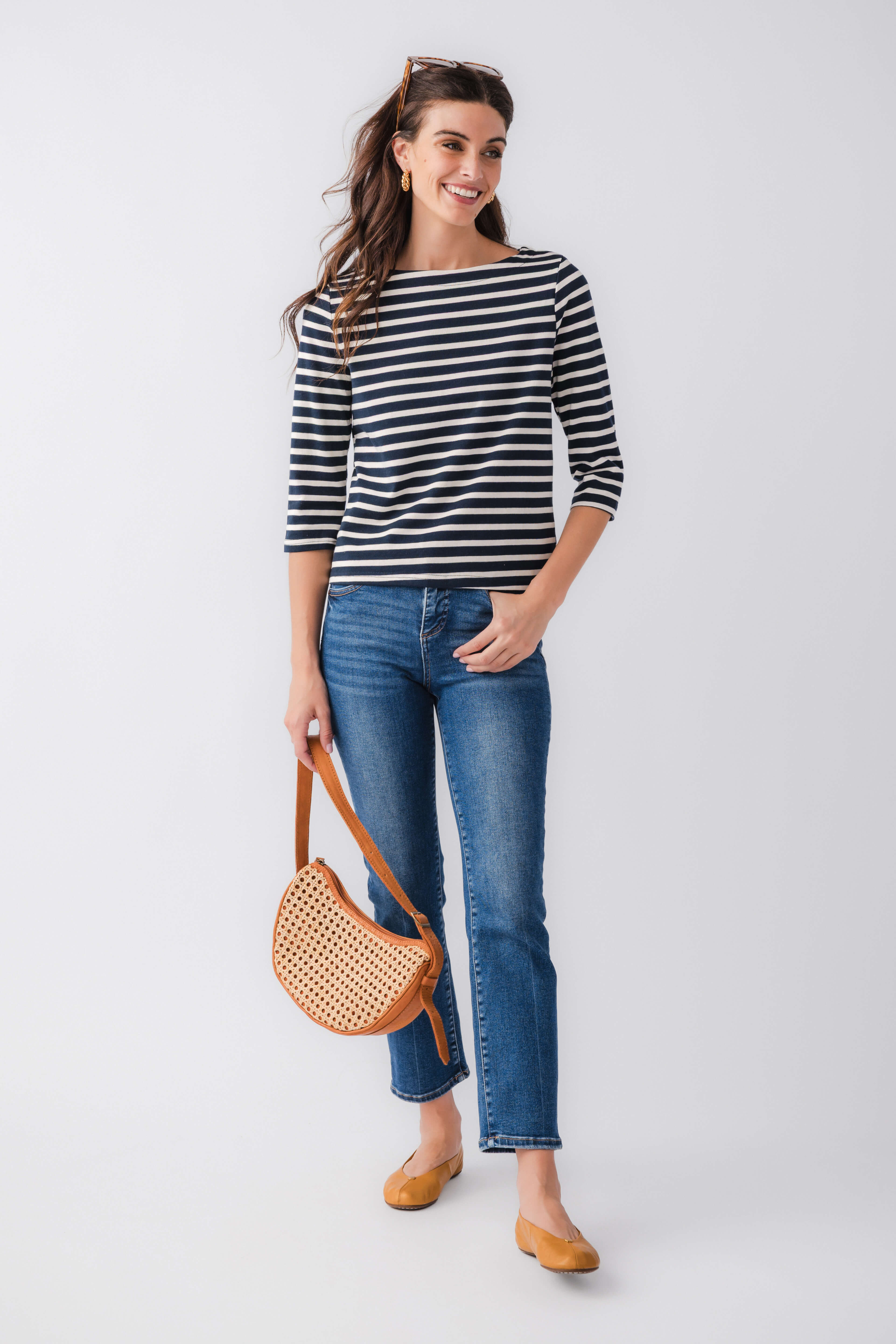 Navy and white striped boatneck top with three-quarter sleeves, paired with jeans