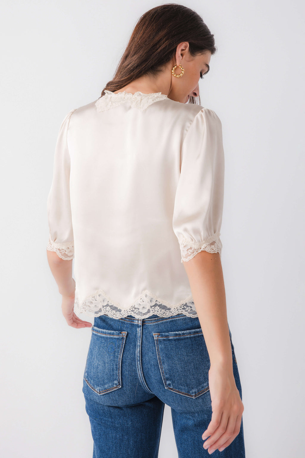 Ecru satin blouse top with lace trim at cuffs and hem, back view