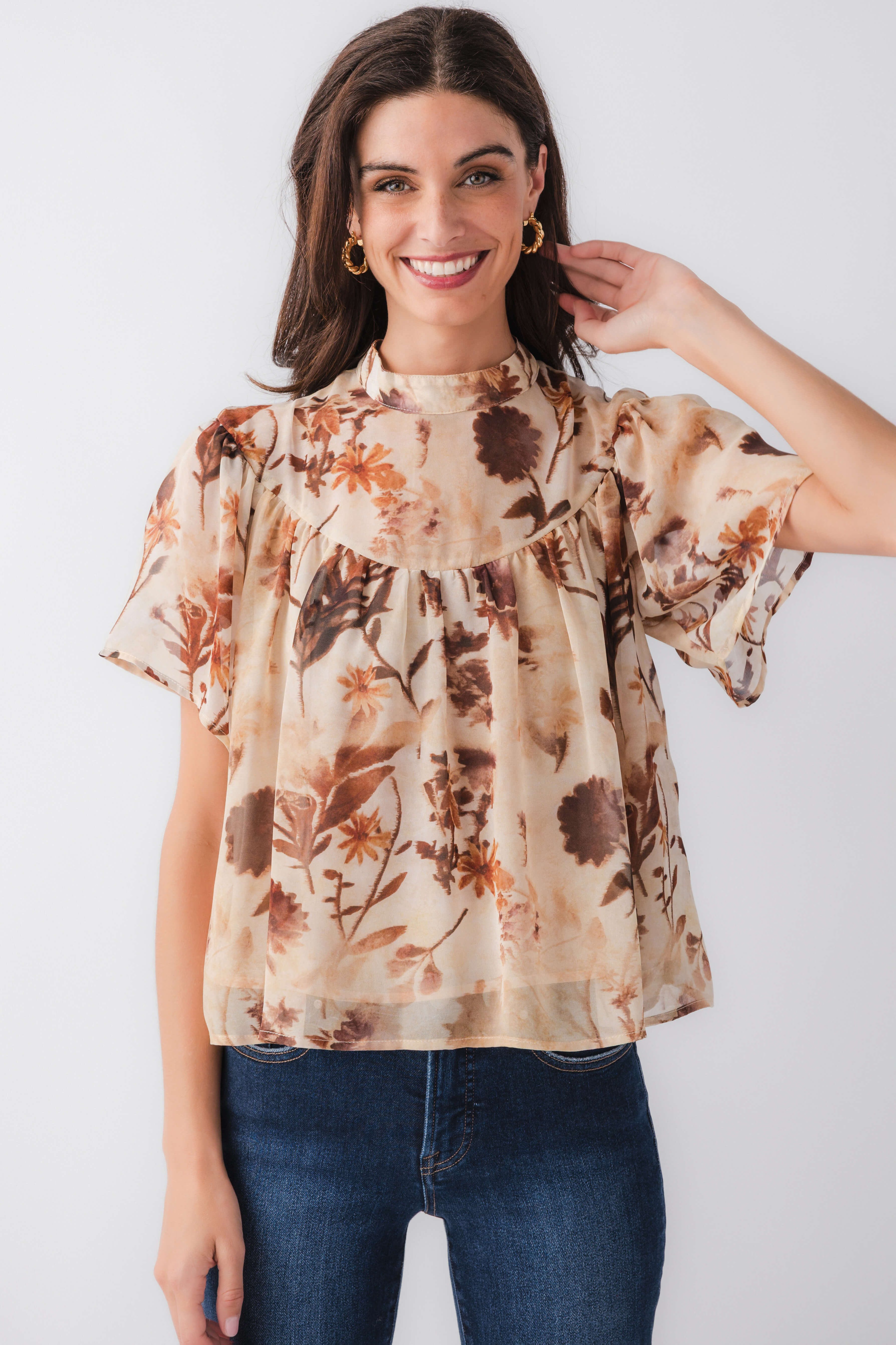 Tan floral blouse top with ruffled neckline and short flutter sleeves