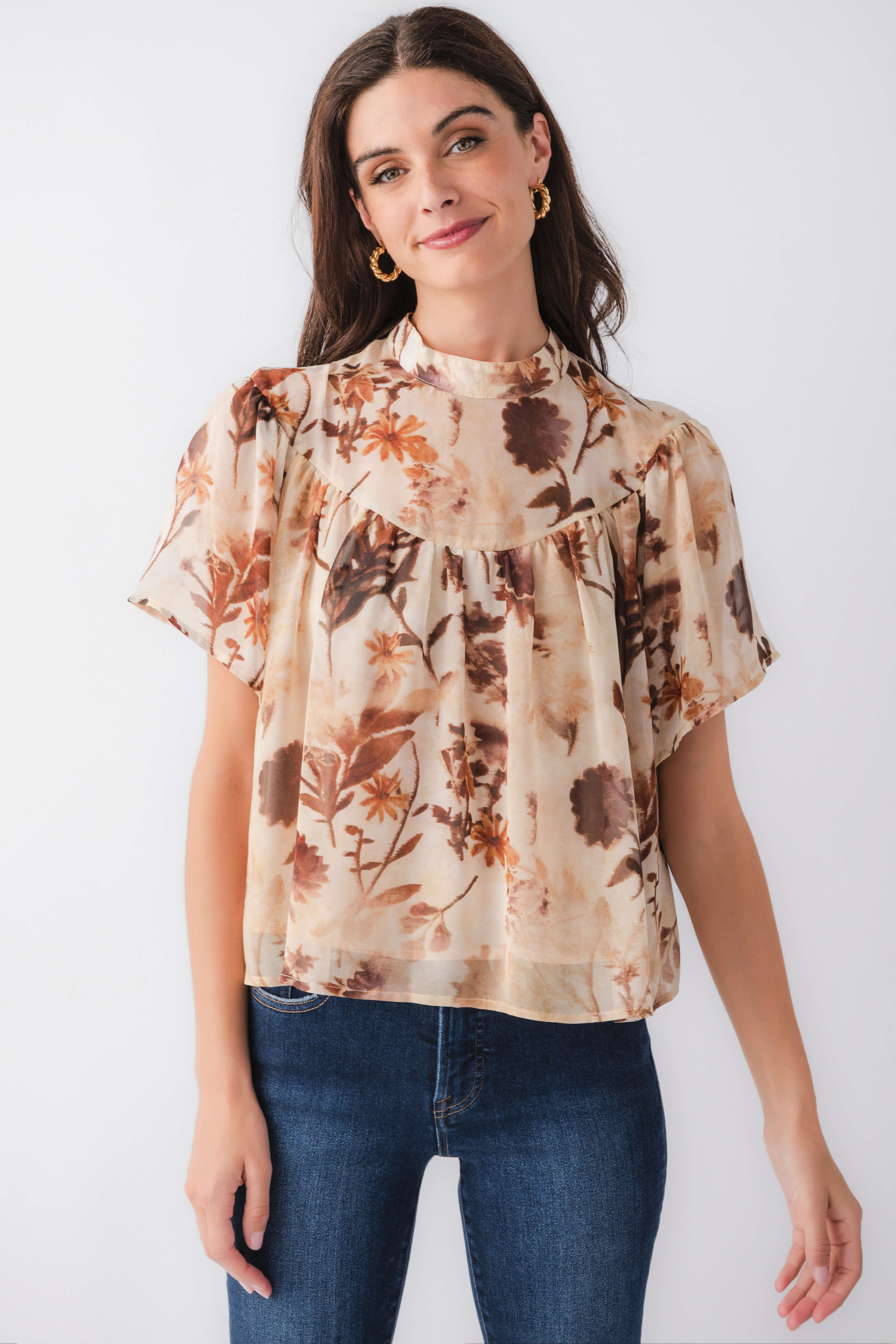 Tan floral short-sleeve blouse with ruffled high neckline