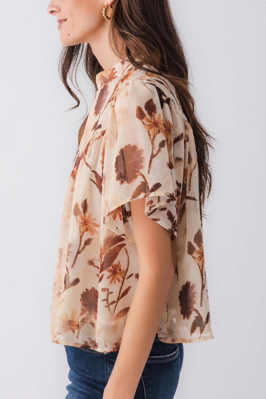 Tan floral blouse top with flutter sleeves in profile view