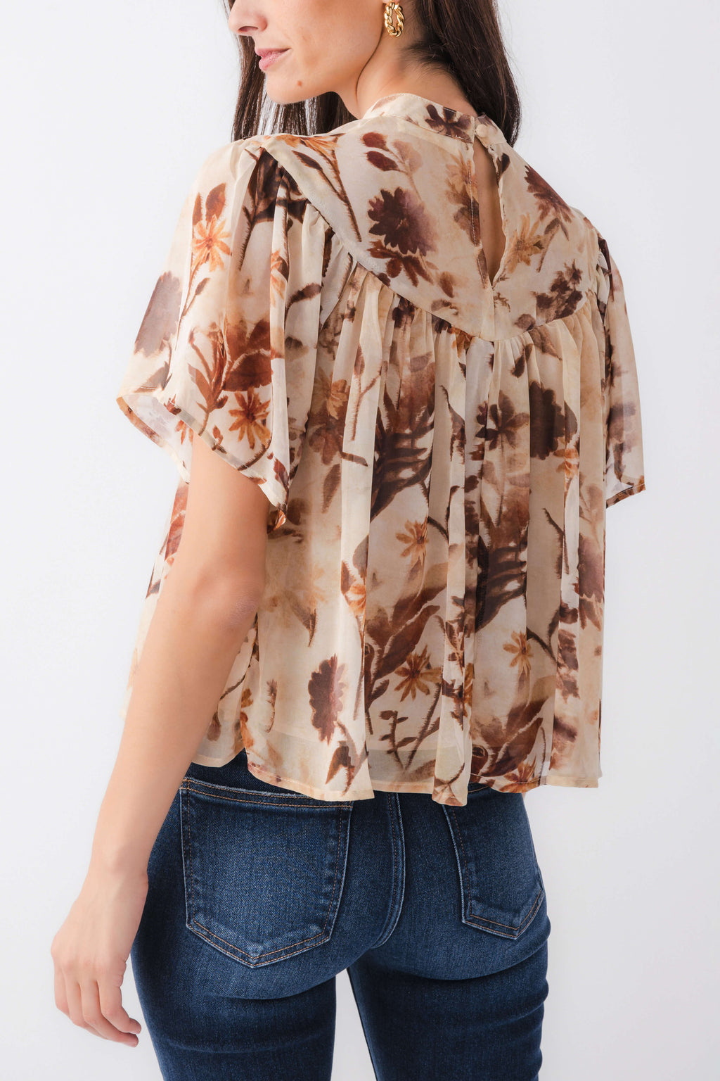 Tan floral blouse top with relaxed fit and ruffled neckline, side/back view