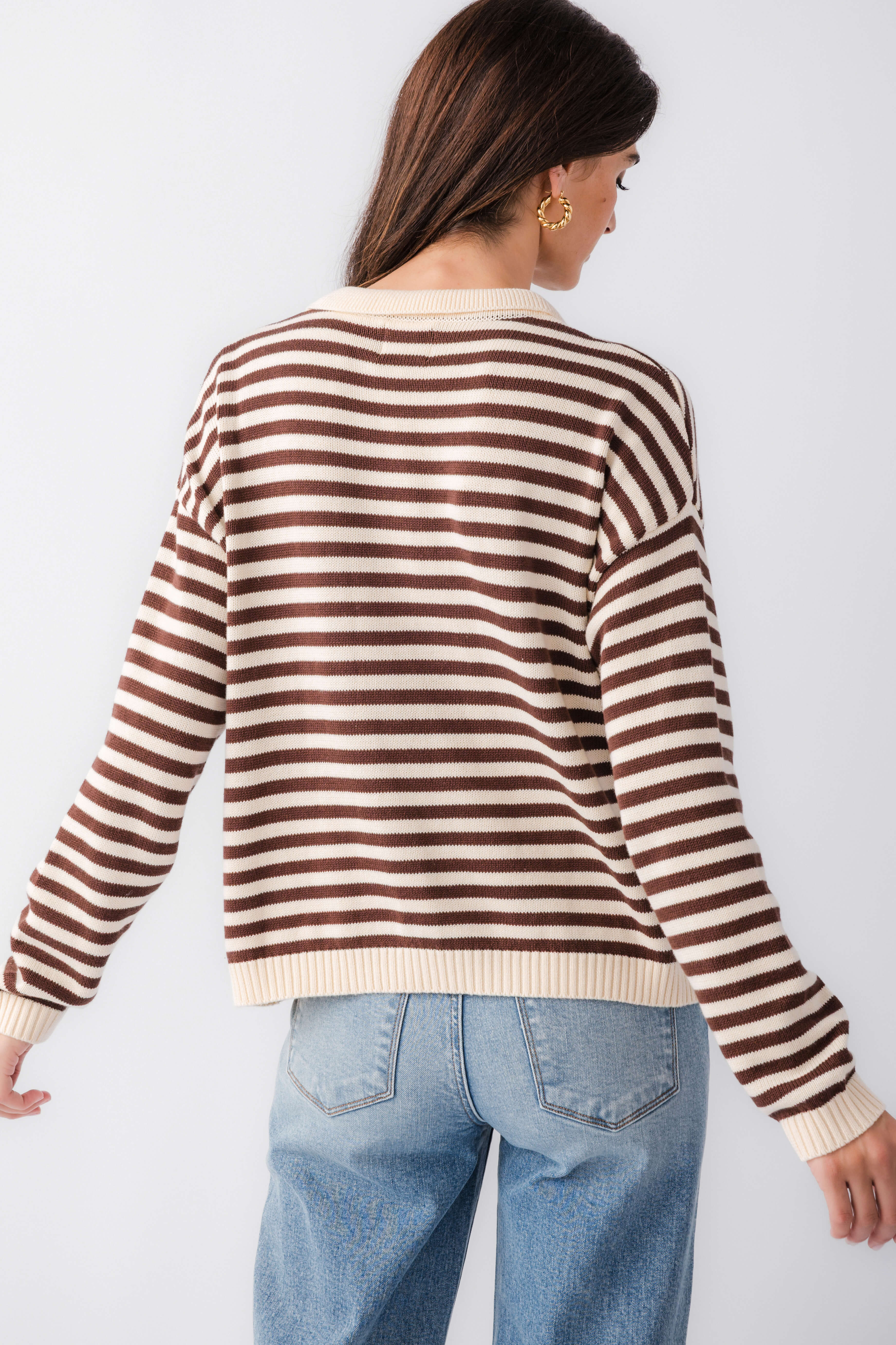 Back view of cream and brown striped collared polo knit sweater, ribbed cuffs
