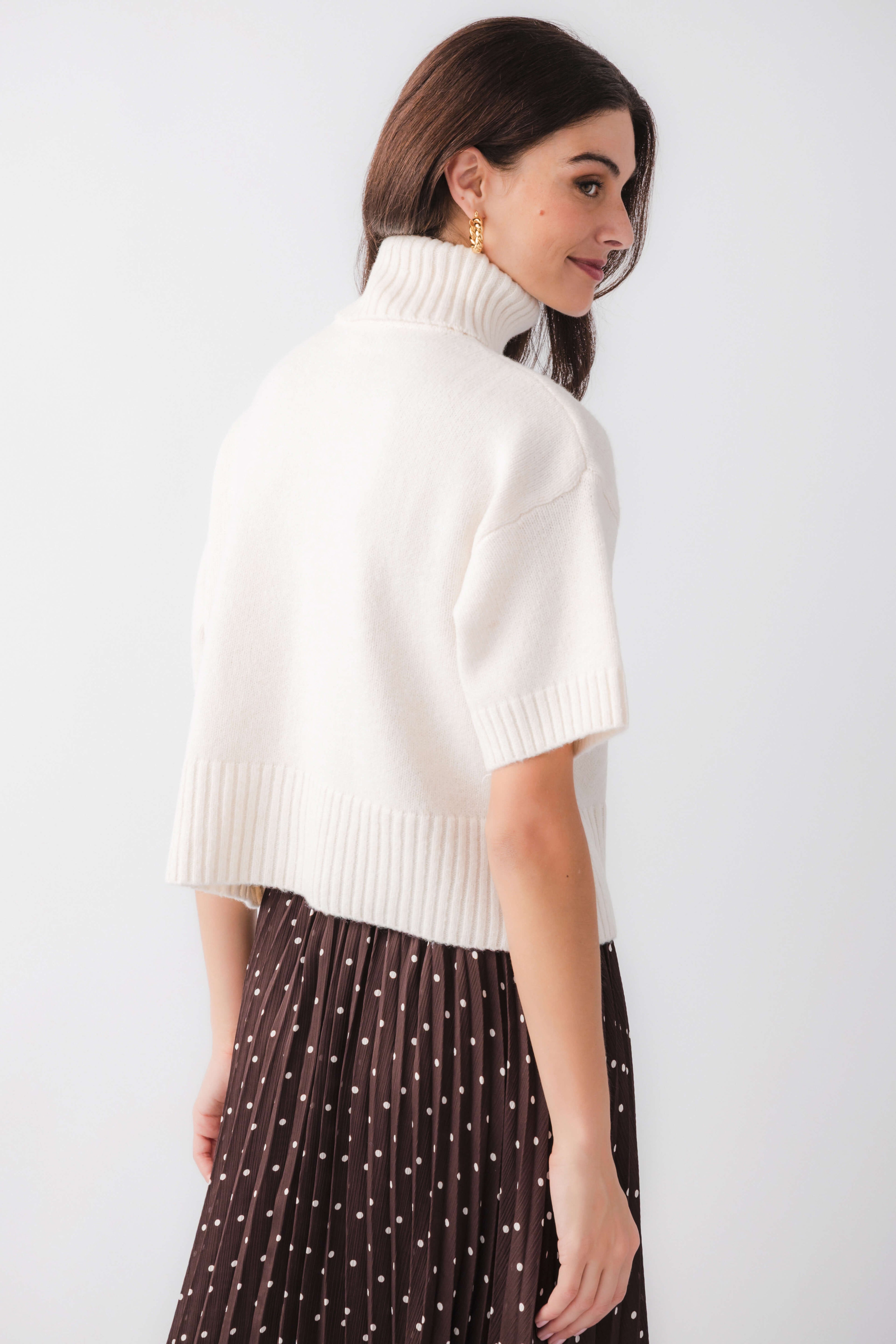 Off-white short-sleeve turtleneck knit sweater, three-quarter back view, ribbed hem