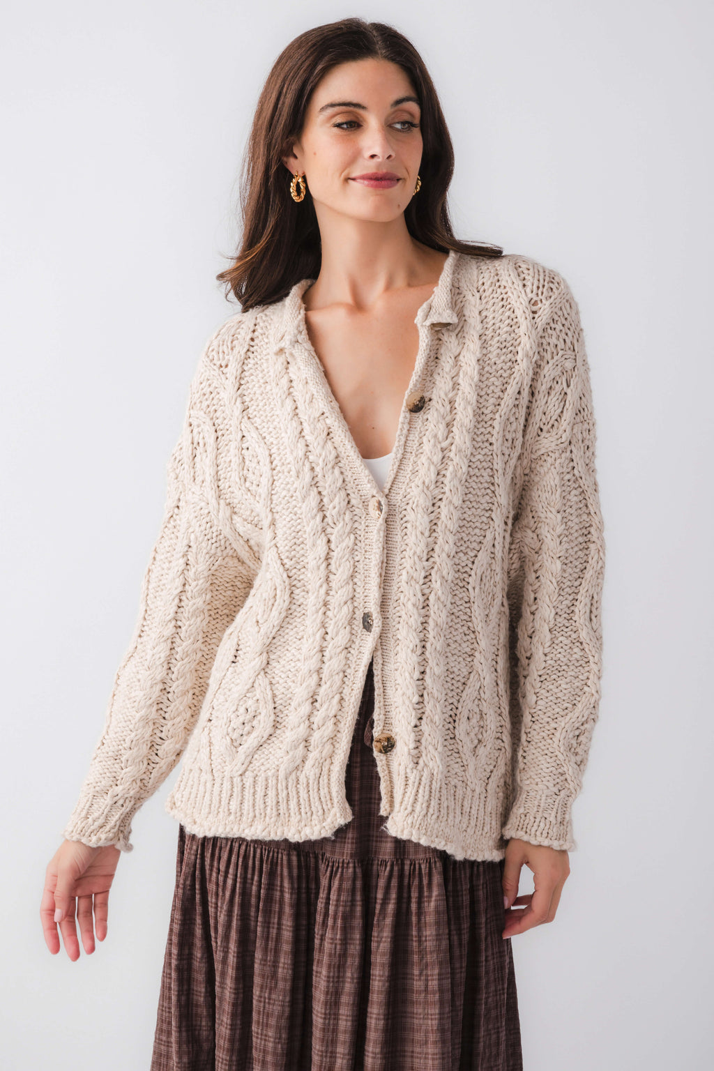 Cream cable-knit cardigan with button front and long sleeves