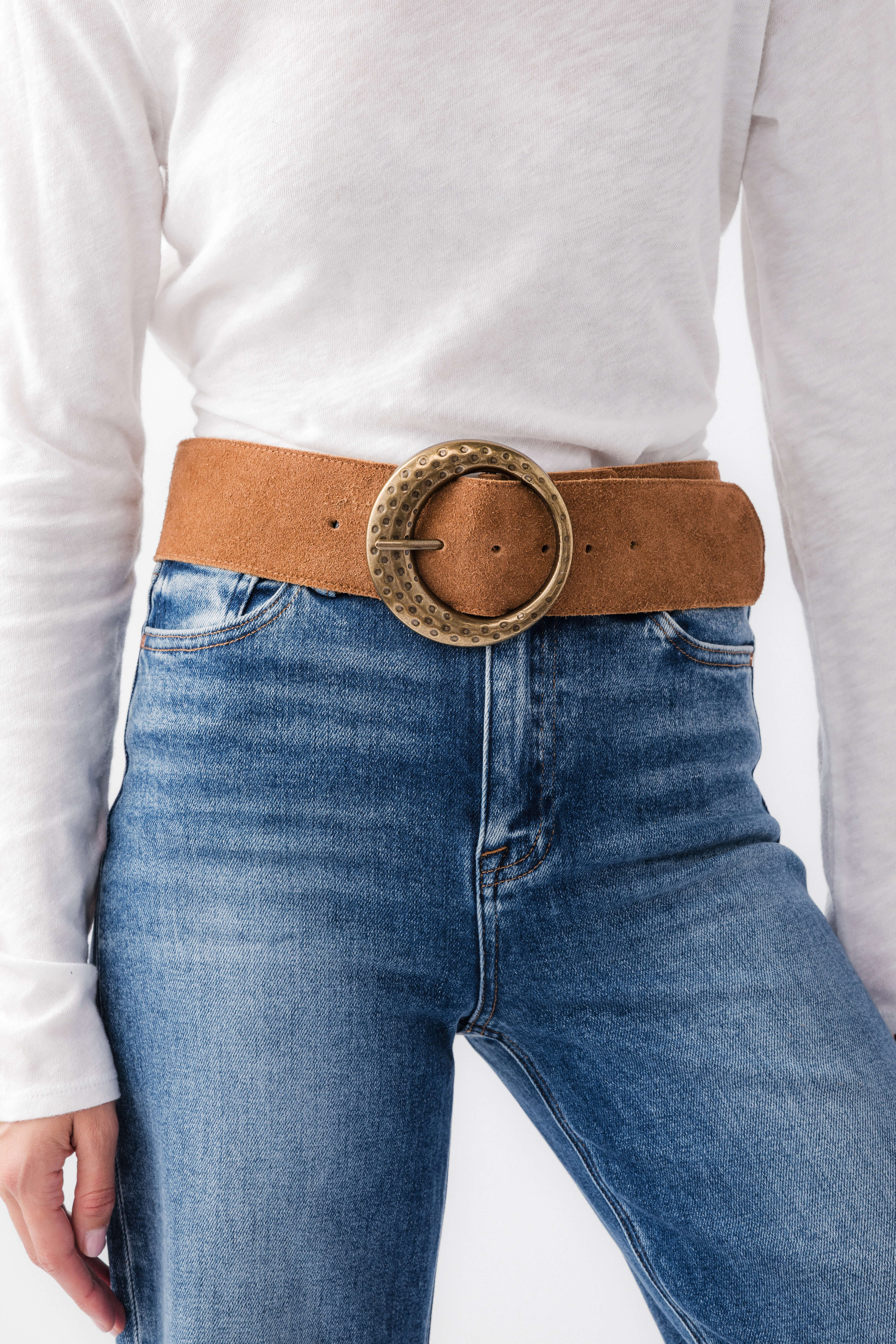Cognac leather hip belt with round studded buckle across denim waistband