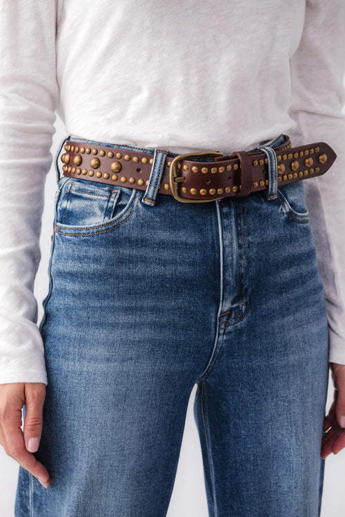 Free People WTF Sola stud belt on jeans, dark brown leather with gold stud trim and buckle.
