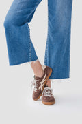 Brown suede sneaker with lace-up front, white laces, and gum sole