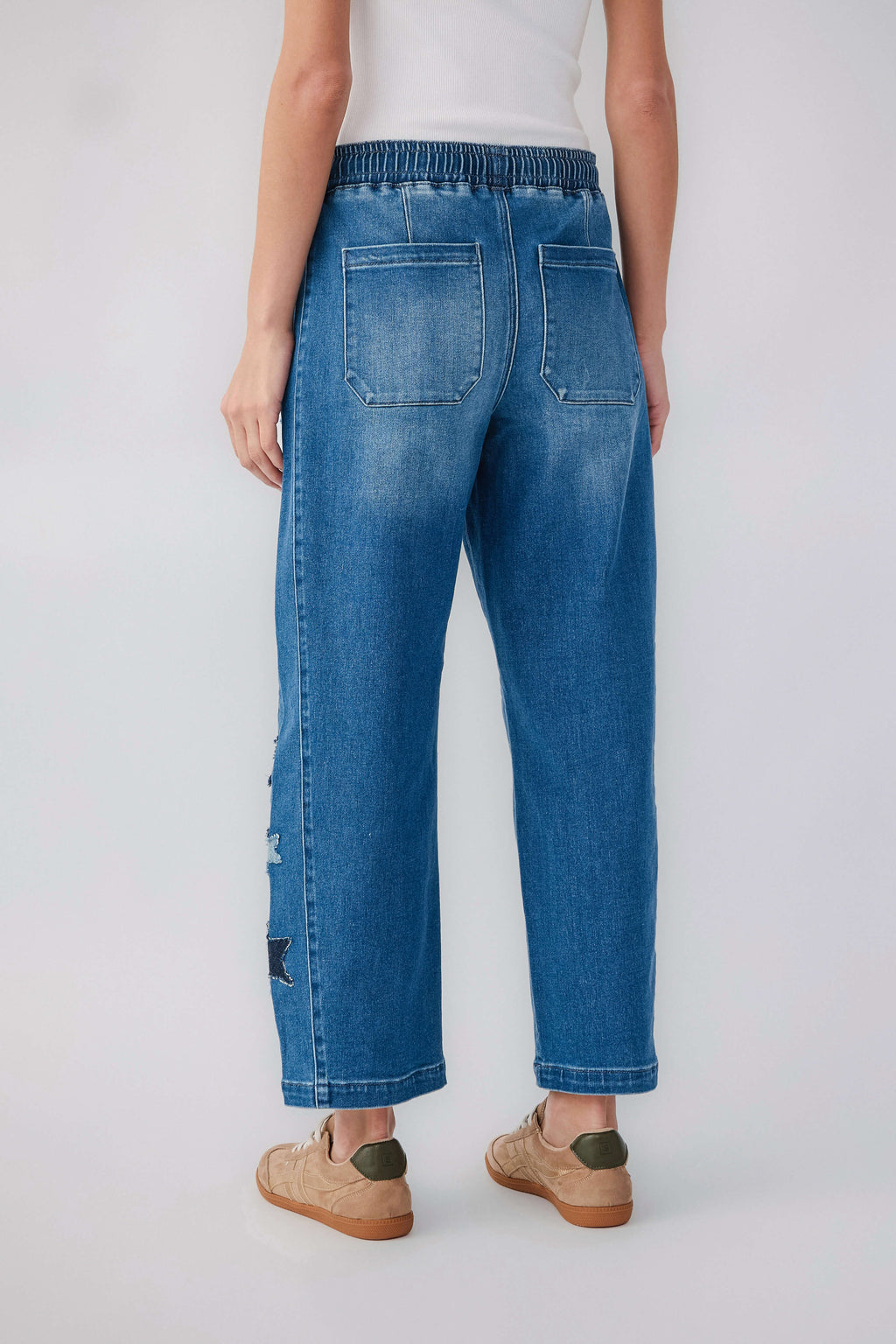 Women's blue barrel jeans with pull-on waistband, back patch pockets, star distressed accents