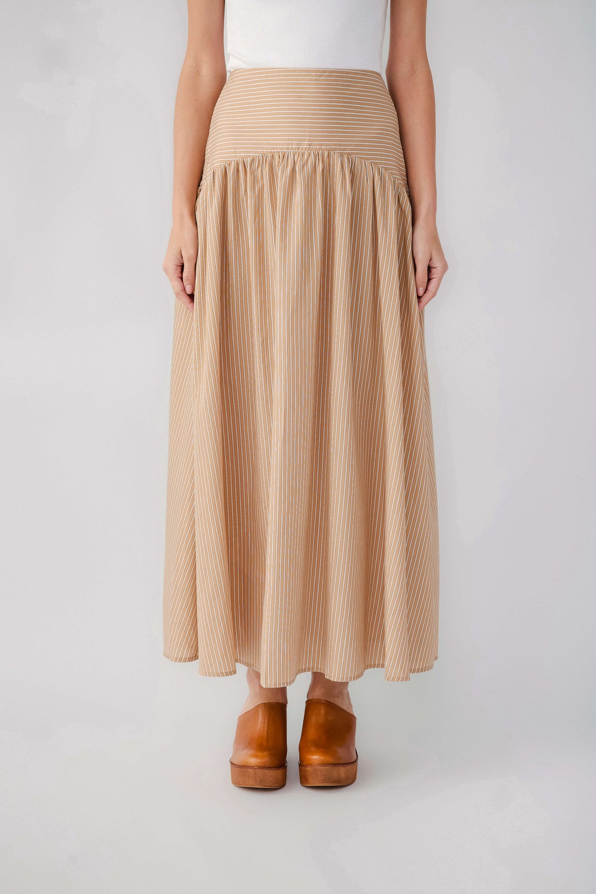 Tan striped maxi skirt with smocked elastic waistband and flowing gathered skirt
