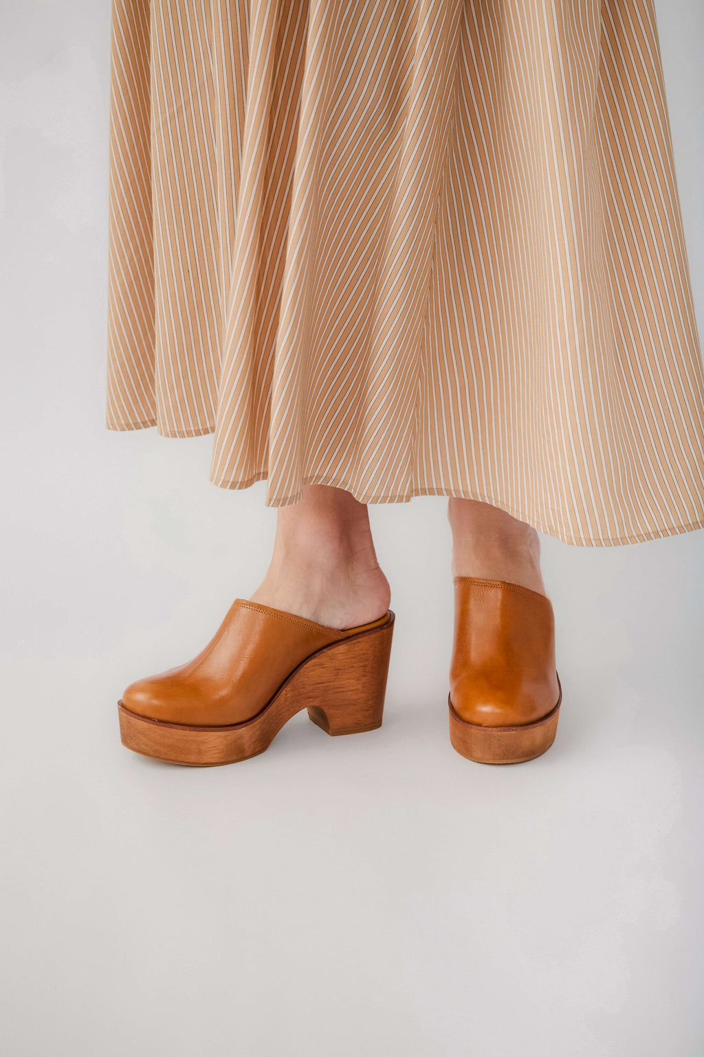 Tan leather wedge clog mules with chunky wood-look heel and slip-on backless design