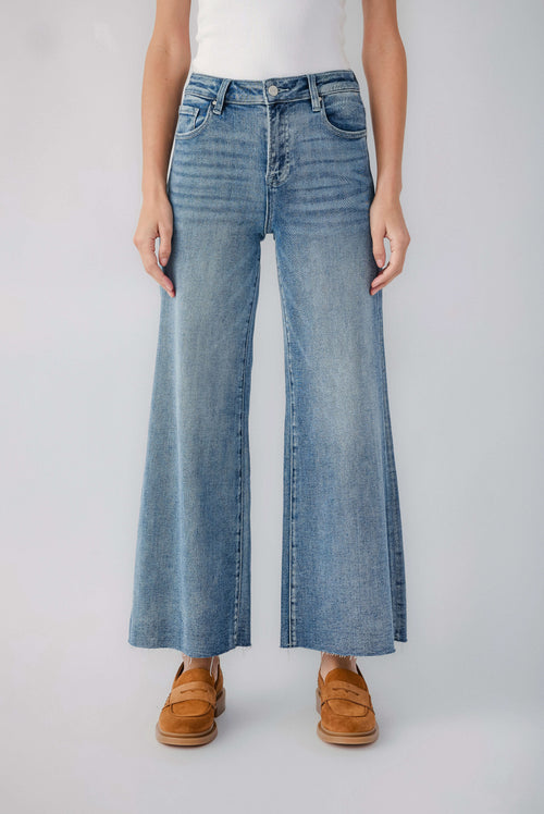 Medium blue wide-leg denim jeans with raw hem and visible belt loops